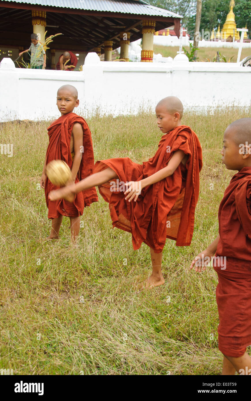Burmese novices playing Sepak Takraw in front of a temple. Stock Photo