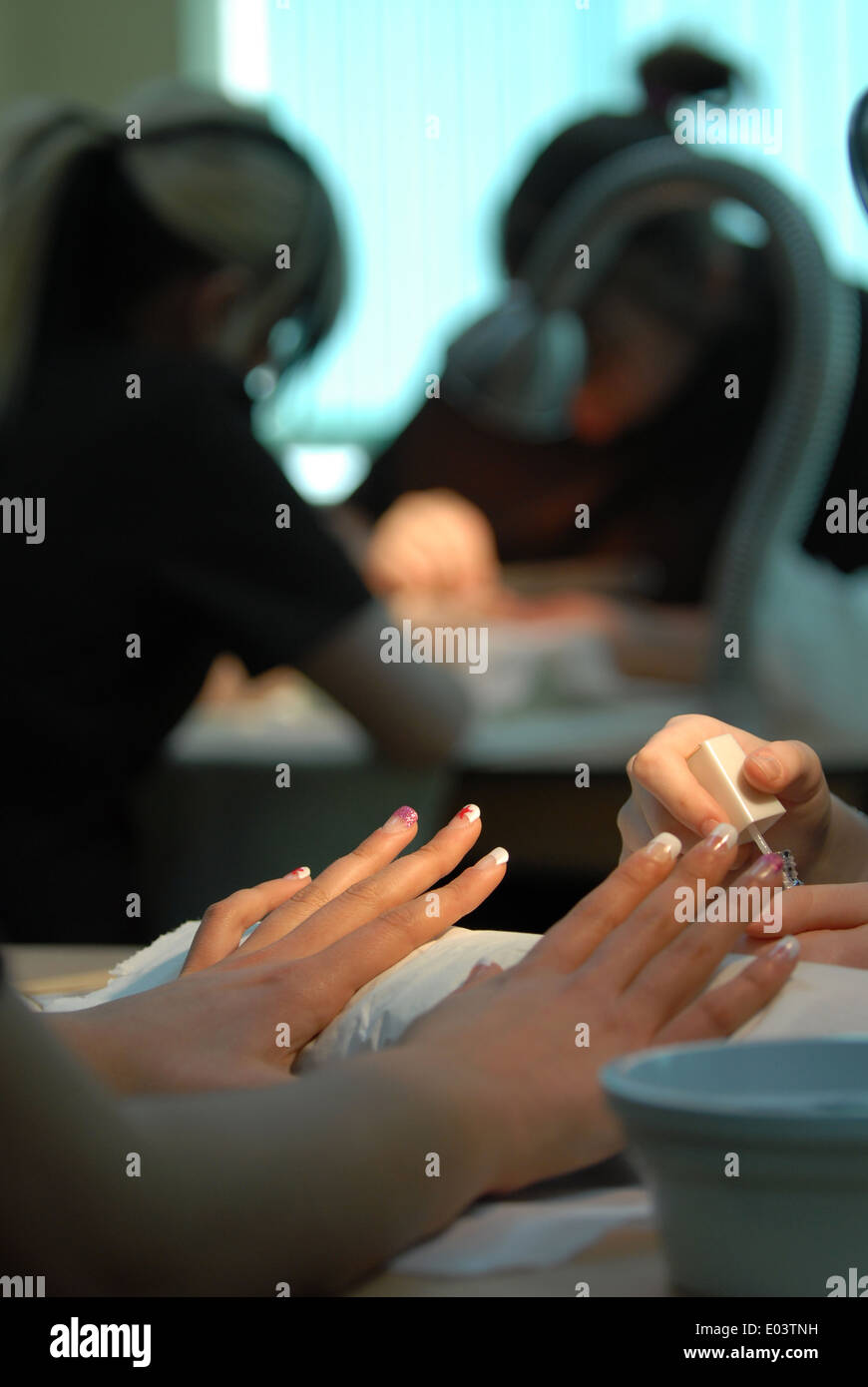 Hands at a nail bar, or having a manicure. Stock Photo