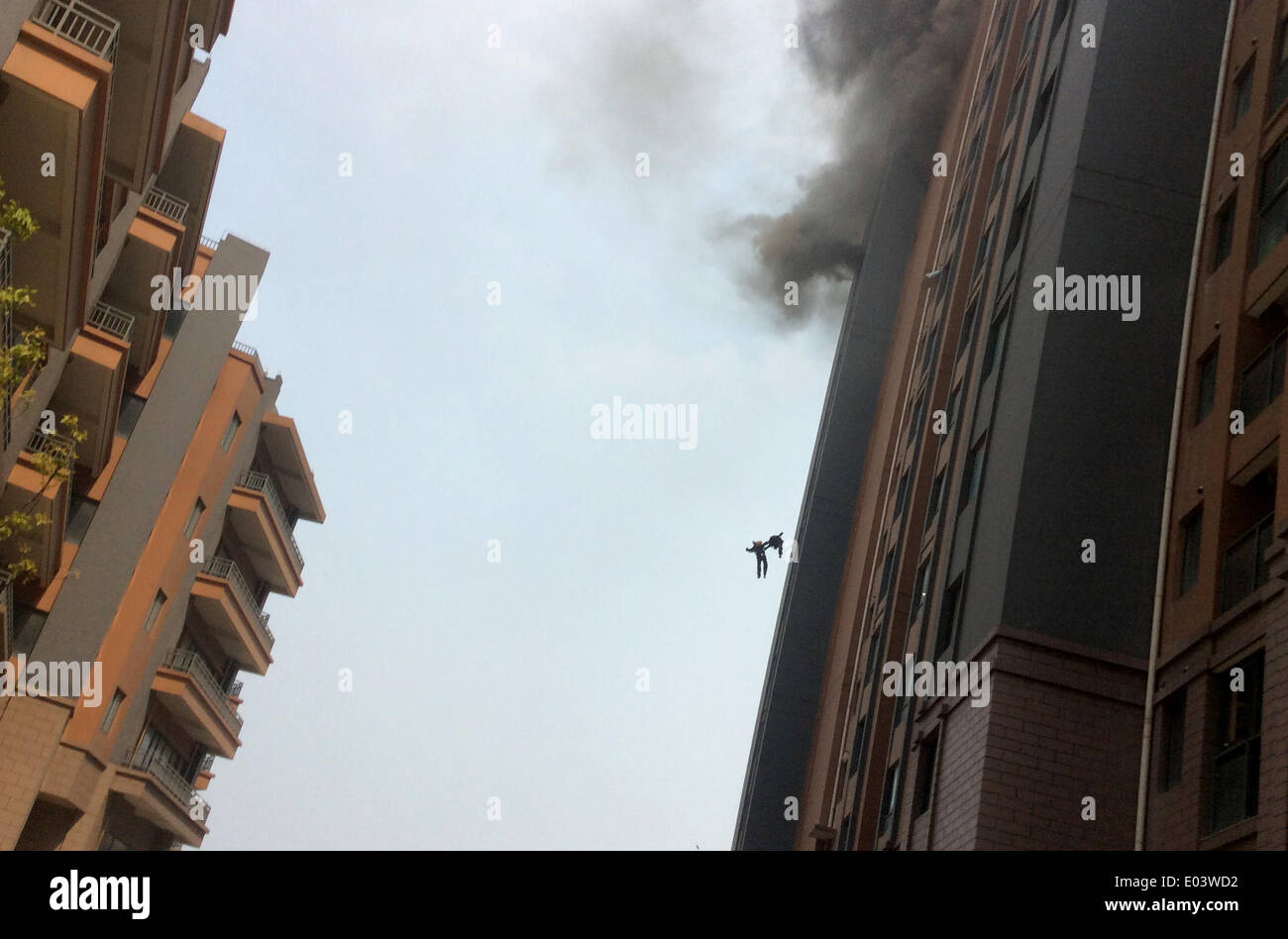 (140501) -- SHANGHAI, May 1, 2014 (Xinhua) -- Photo taken by a local resident shows two firefighters falling down from a building in Shanghai, east China, May 1, 2014. The two firefighters fell from the 13th floor of a residential building when they were putting out a fire on Thursday afternoon. The two young men, both in their 20s, died despite rescue efforts. (Xinhua) (ry) Stock Photo