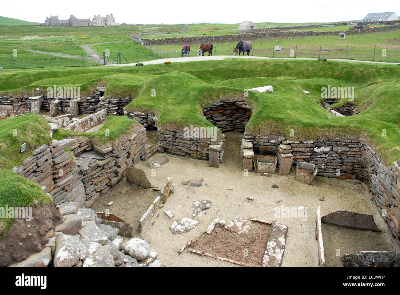 Skara Brae neolithic settlement, Bay of Skaill, Mainland, Orkney. The patch of reddish earth indicates the hearth of the hut. Stock Photo
