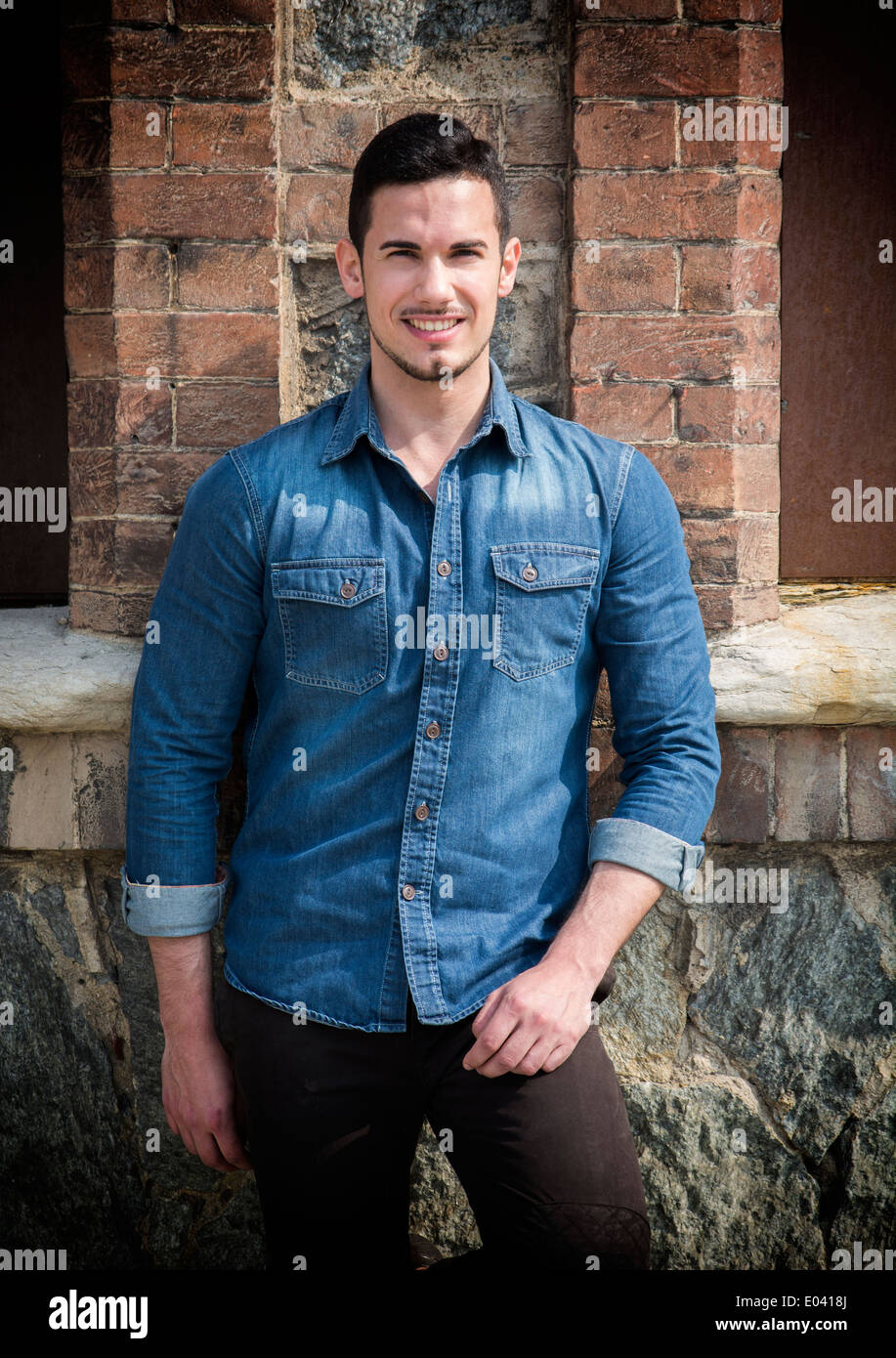 Young man standing front wall hi-res stock photography and images - Alamy