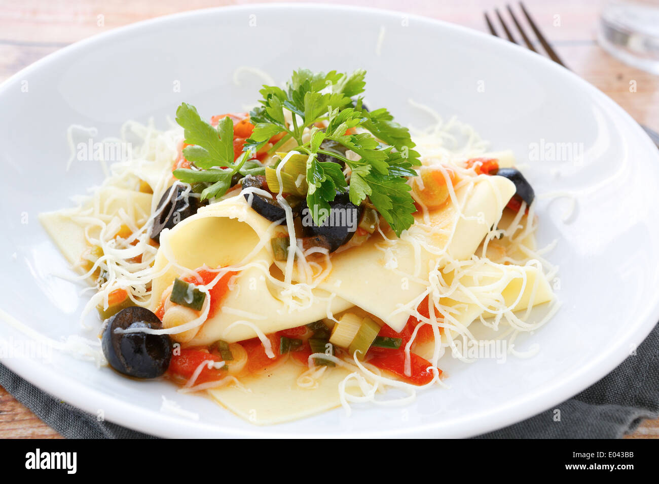 Easy Lasagna with fresh herbs and olives, food closeup Stock Photo