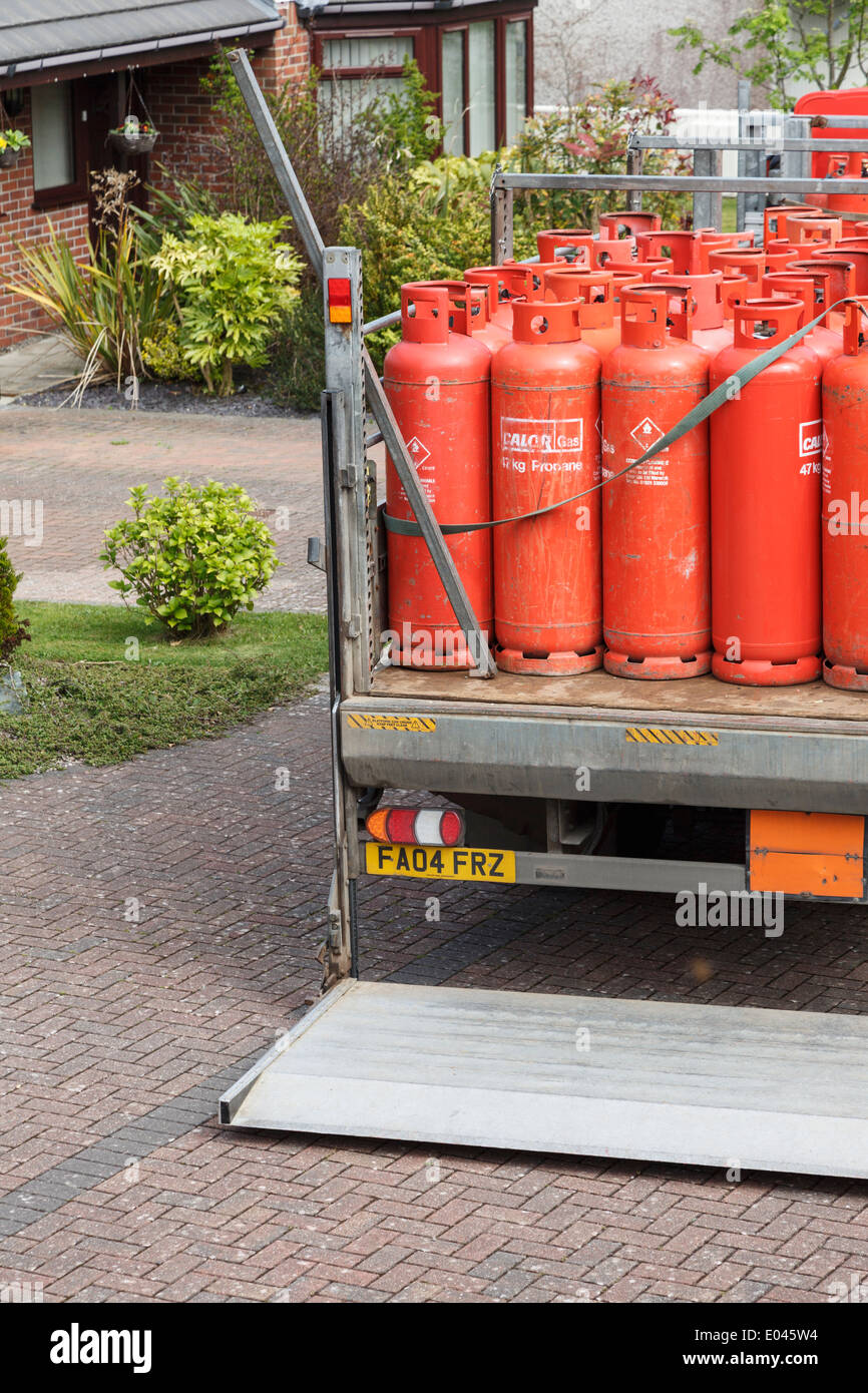 UK, Britain. A delivery of household red Calor Gas bottles on back of a pickup truck outside a house. Stock Photo