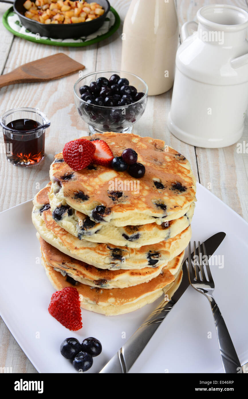 High angle shot of a stack of fresh homemade blueberry pancakes. The plate is on a rustic farmhouse style kitchen table Stock Photo