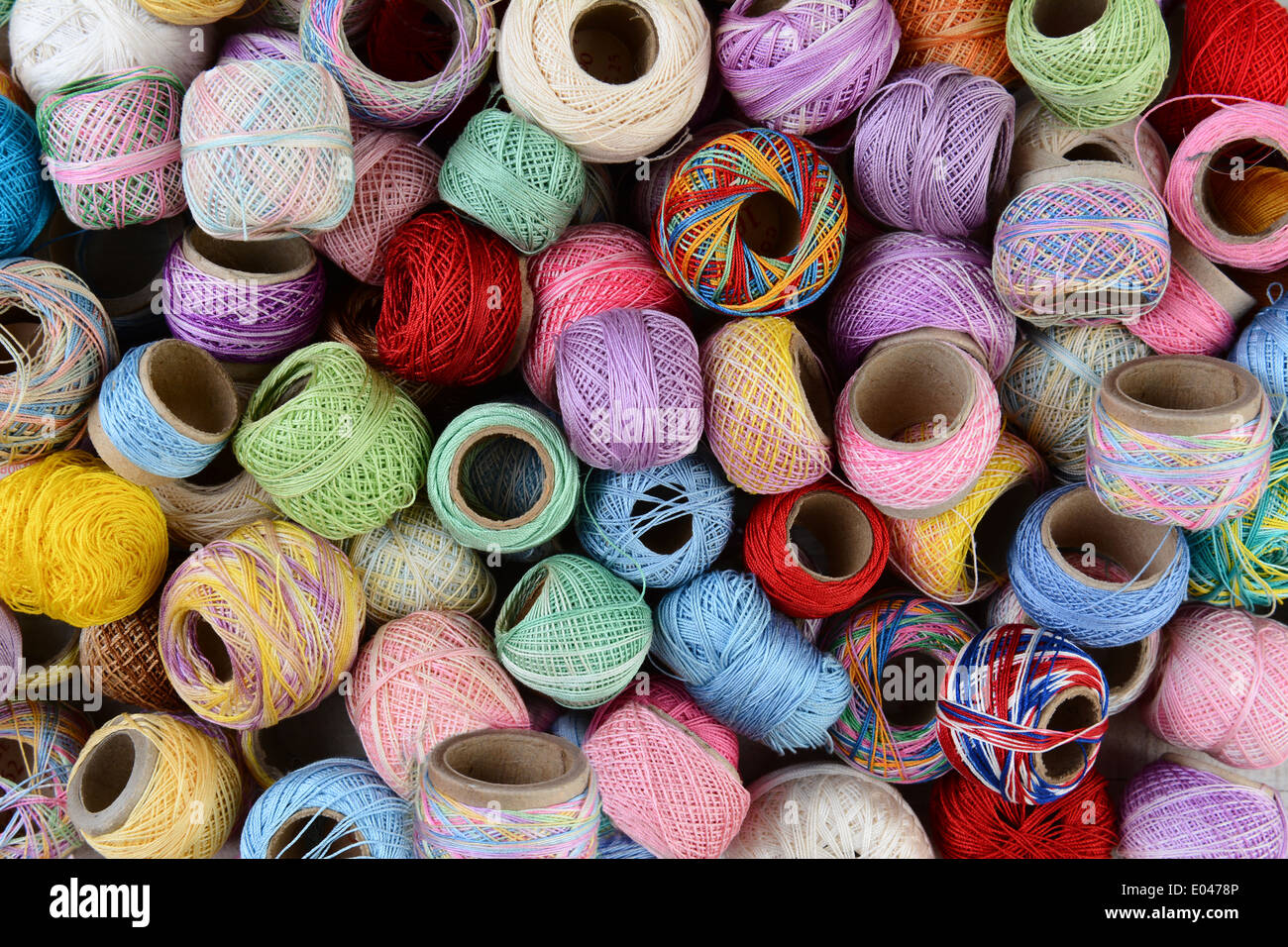 Closeup of a variety of small spools of thread. Horizontal format filling the frame. Stock Photo