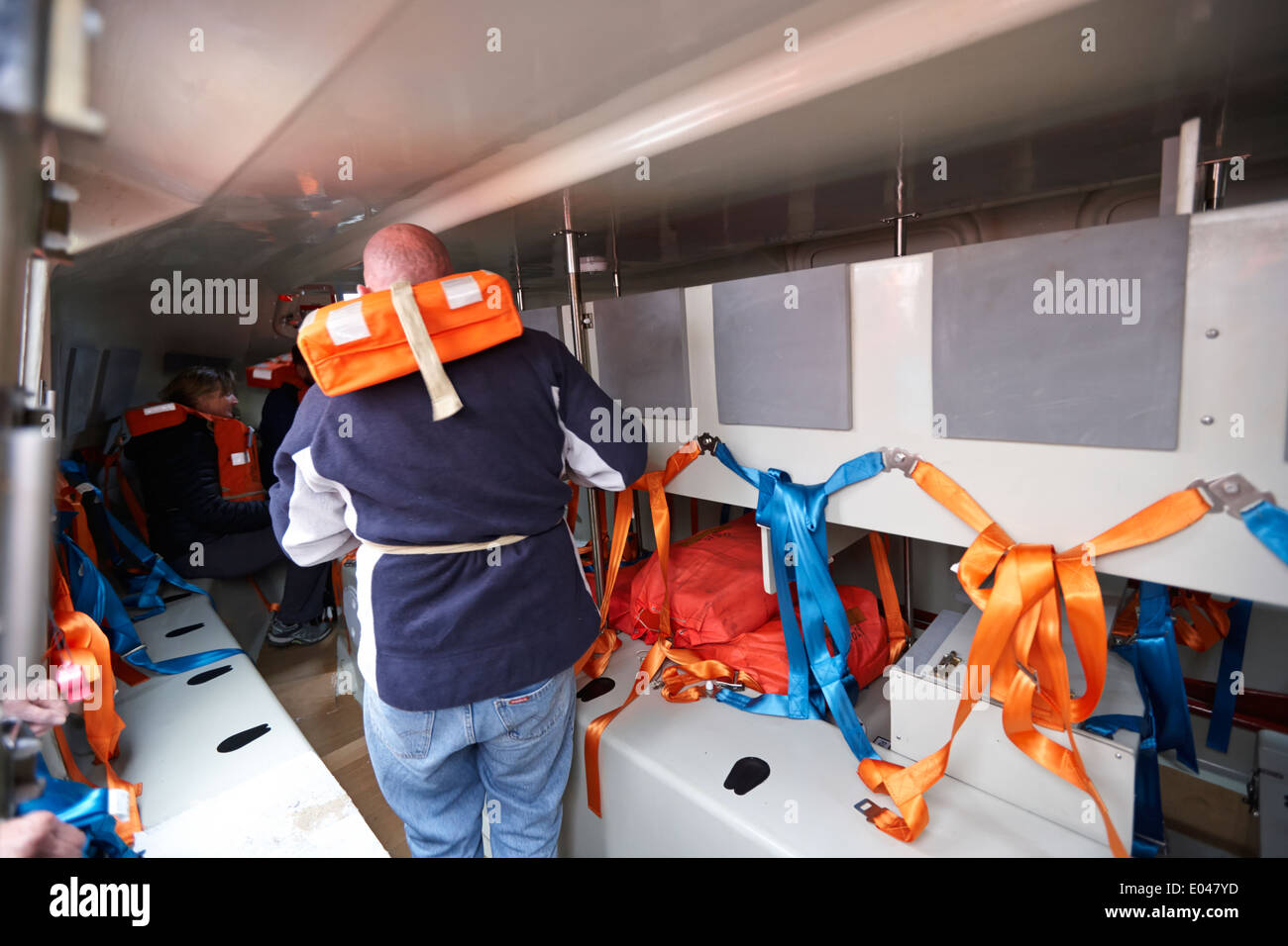tourists during lifeboat drill in interior of an emergency lifeboat on board a cruise ship Stock Photo
