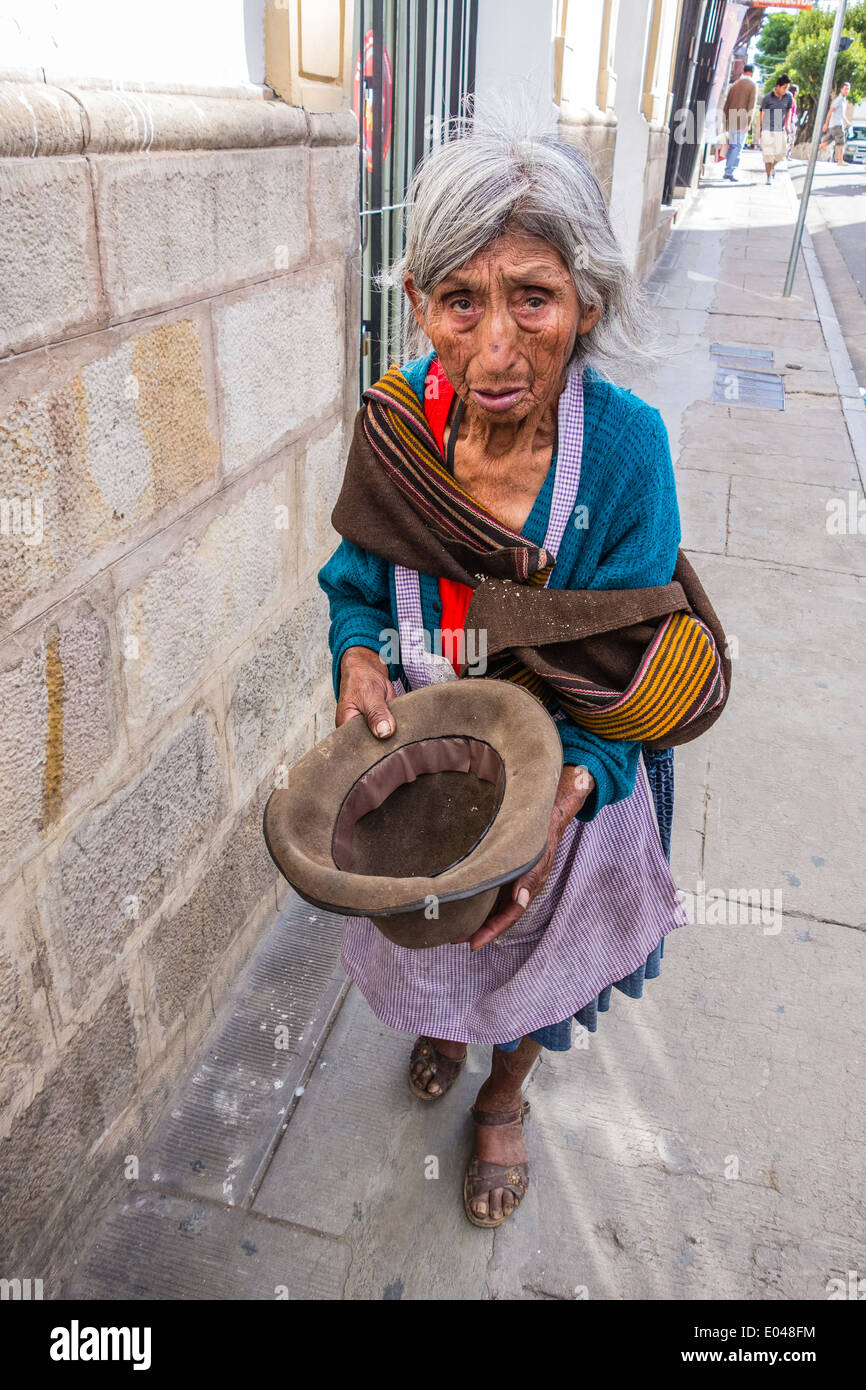 Bolivian woman beggar holding an empty hat out for money on a sidewalk in  the central part of the city of Sucre Stock Photo - Alamy