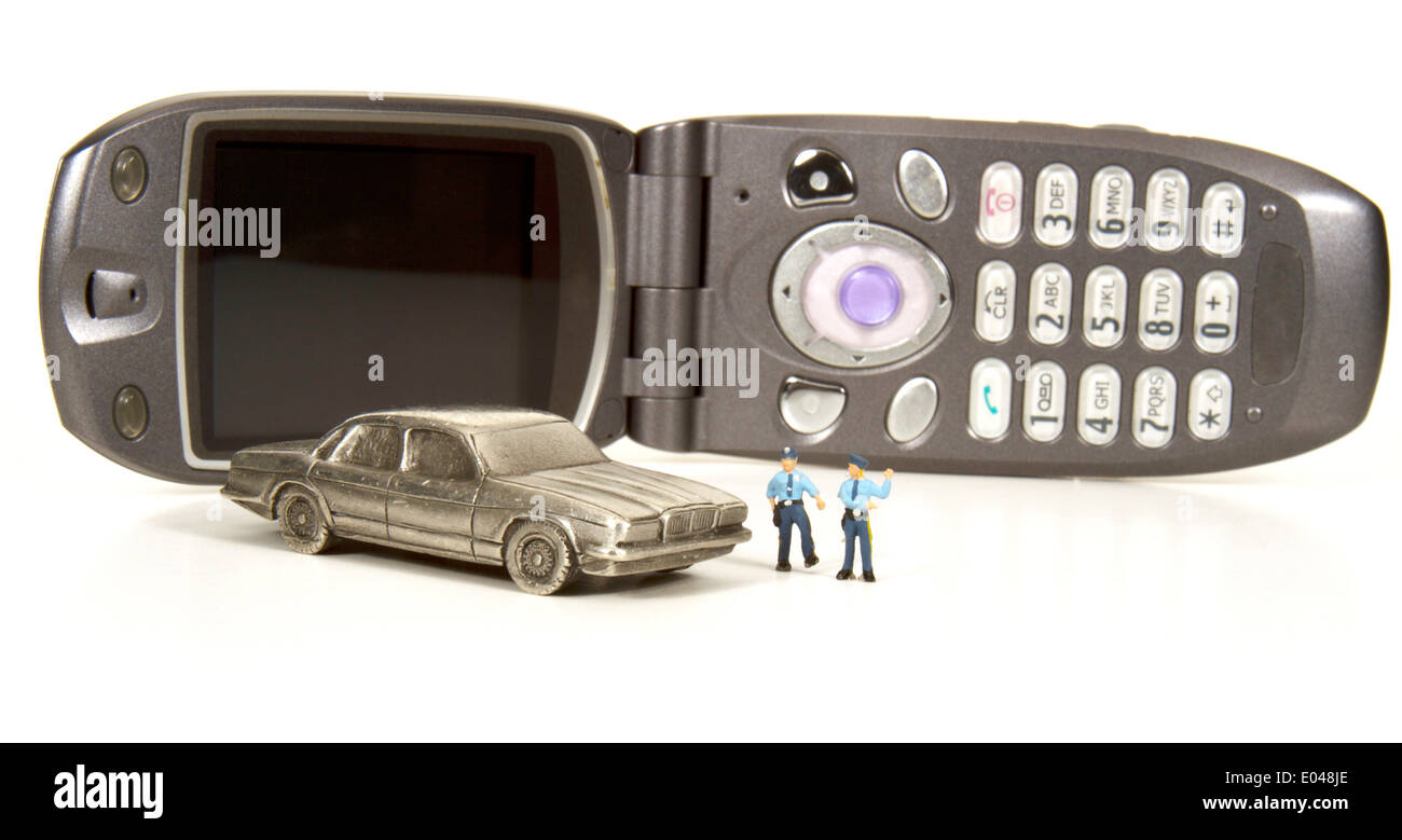 Miniature policemen making a traffic stop with a cell phone in the background Stock Photo