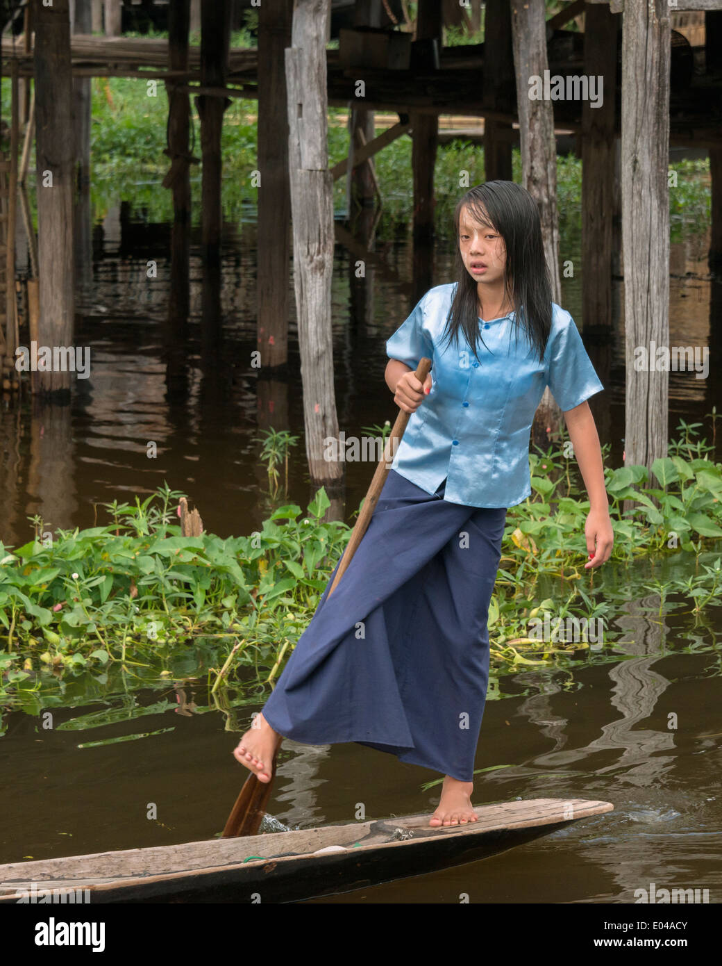 Girl leg rowing a dugout canoe, Inle Lake, Myanmar Stock Photo