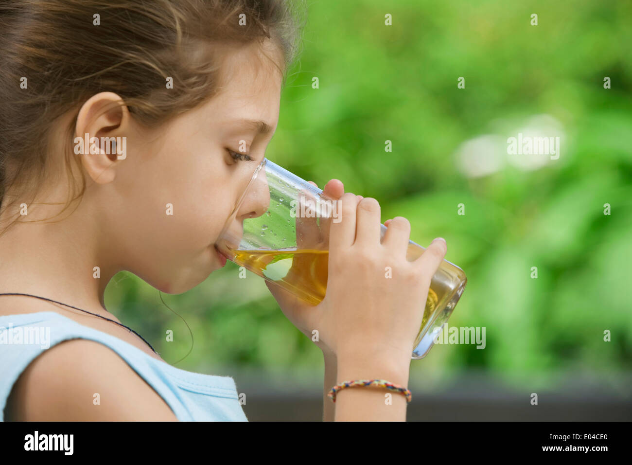 portrait of nice little girl drinking juice in summer environment Stock ...