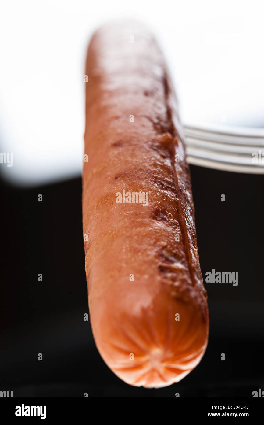 a delicious sausage on a fork over white Stock Photo