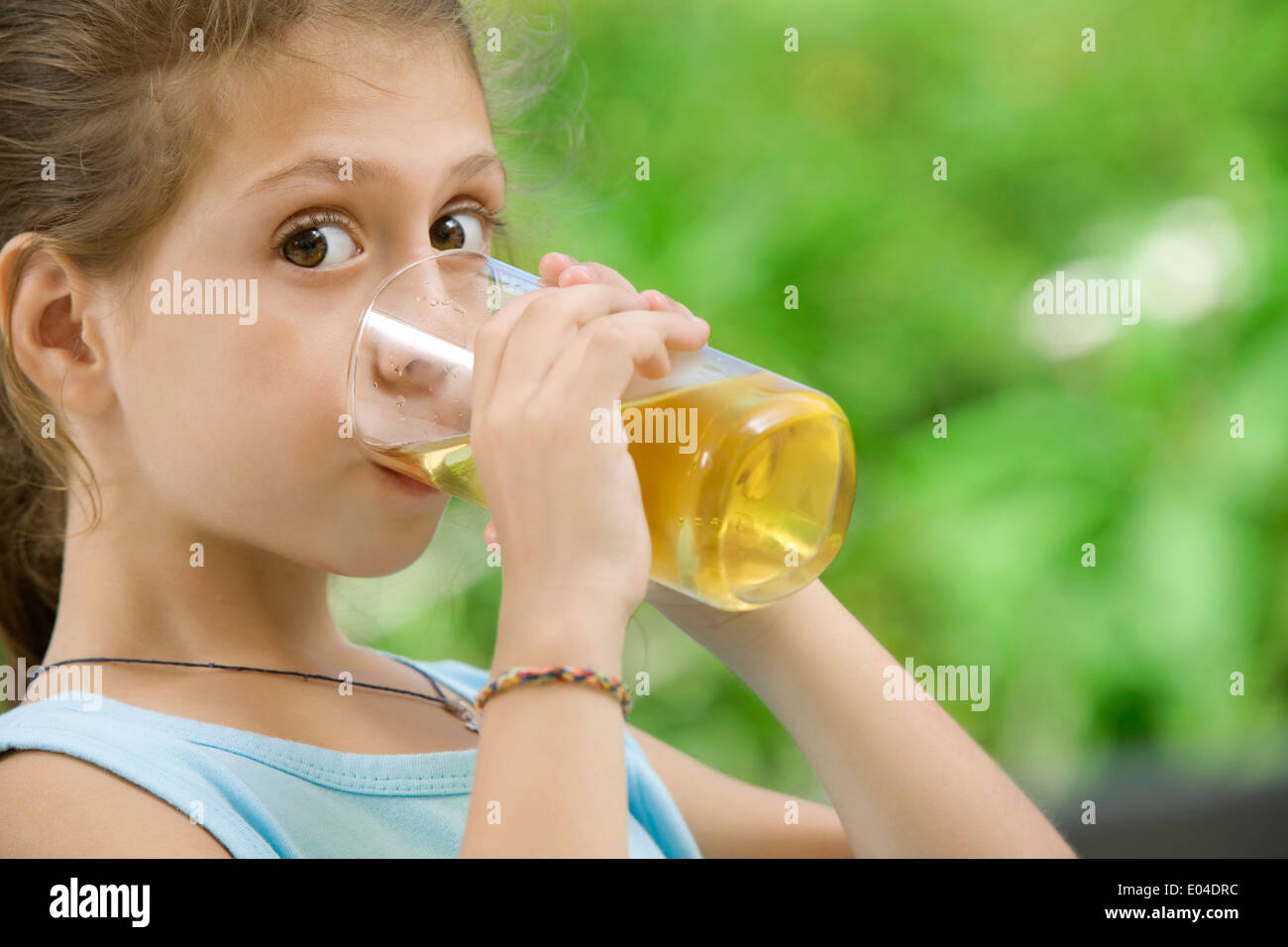 portrait of nice little girl drinking juice in summer environment Stock ...