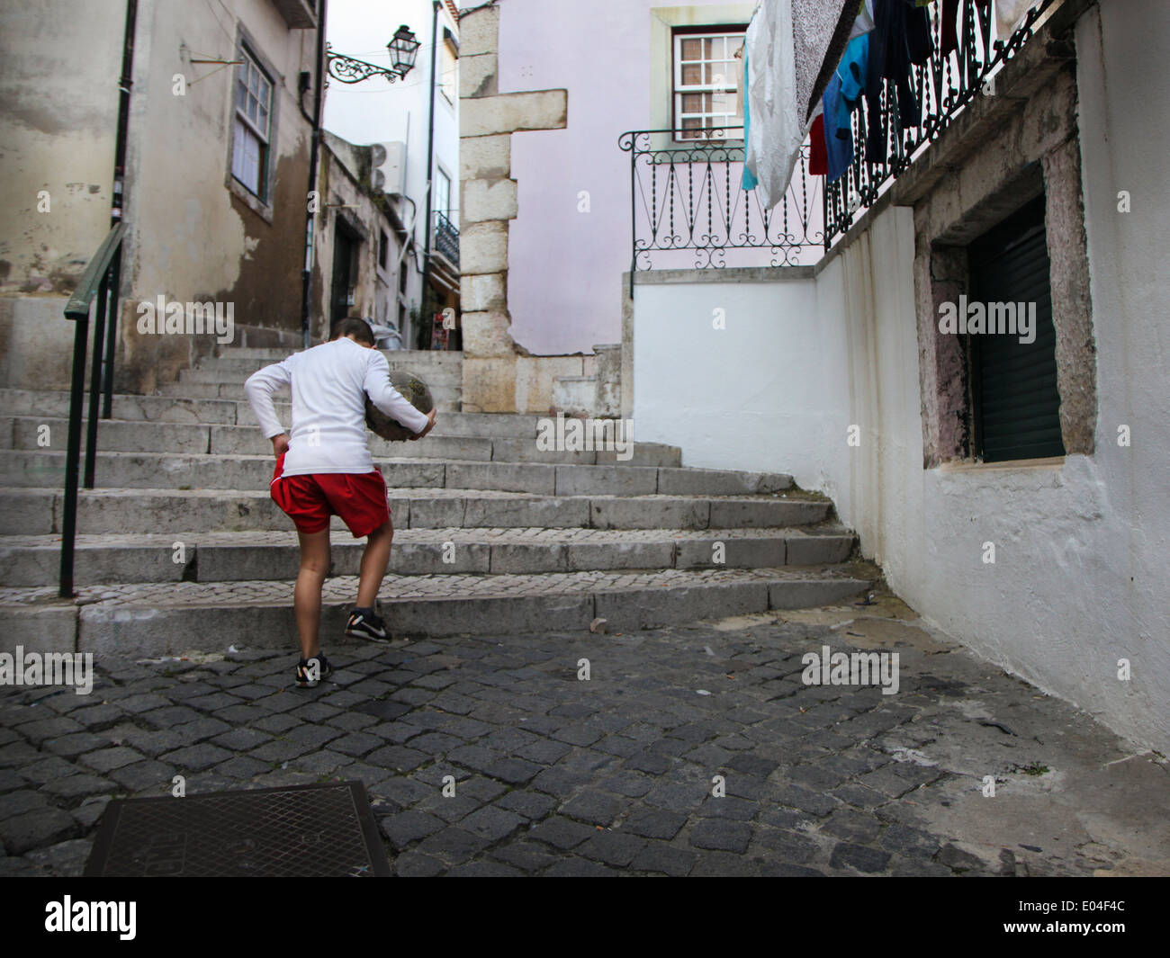 Young boy with a football ball on the street in Lisbon, Portugal Stock Photo