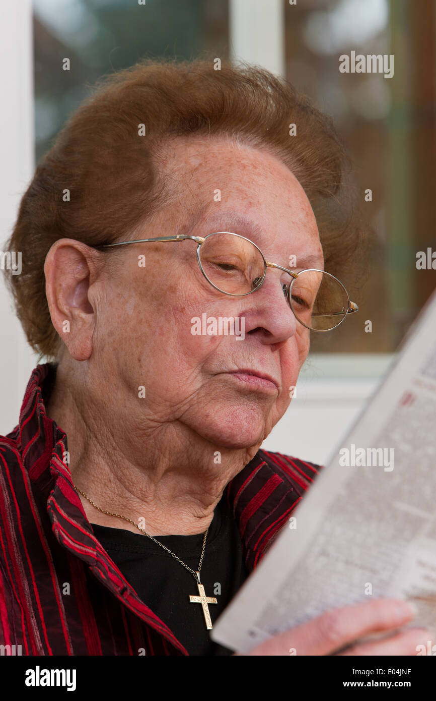 Old woman reads in a newspaper, Alte Frau liest in einer Zeitung Stock Photo