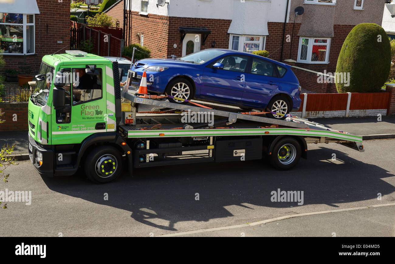 Blue car on the back of a Green Flag car transporter vehicle Stock Photo