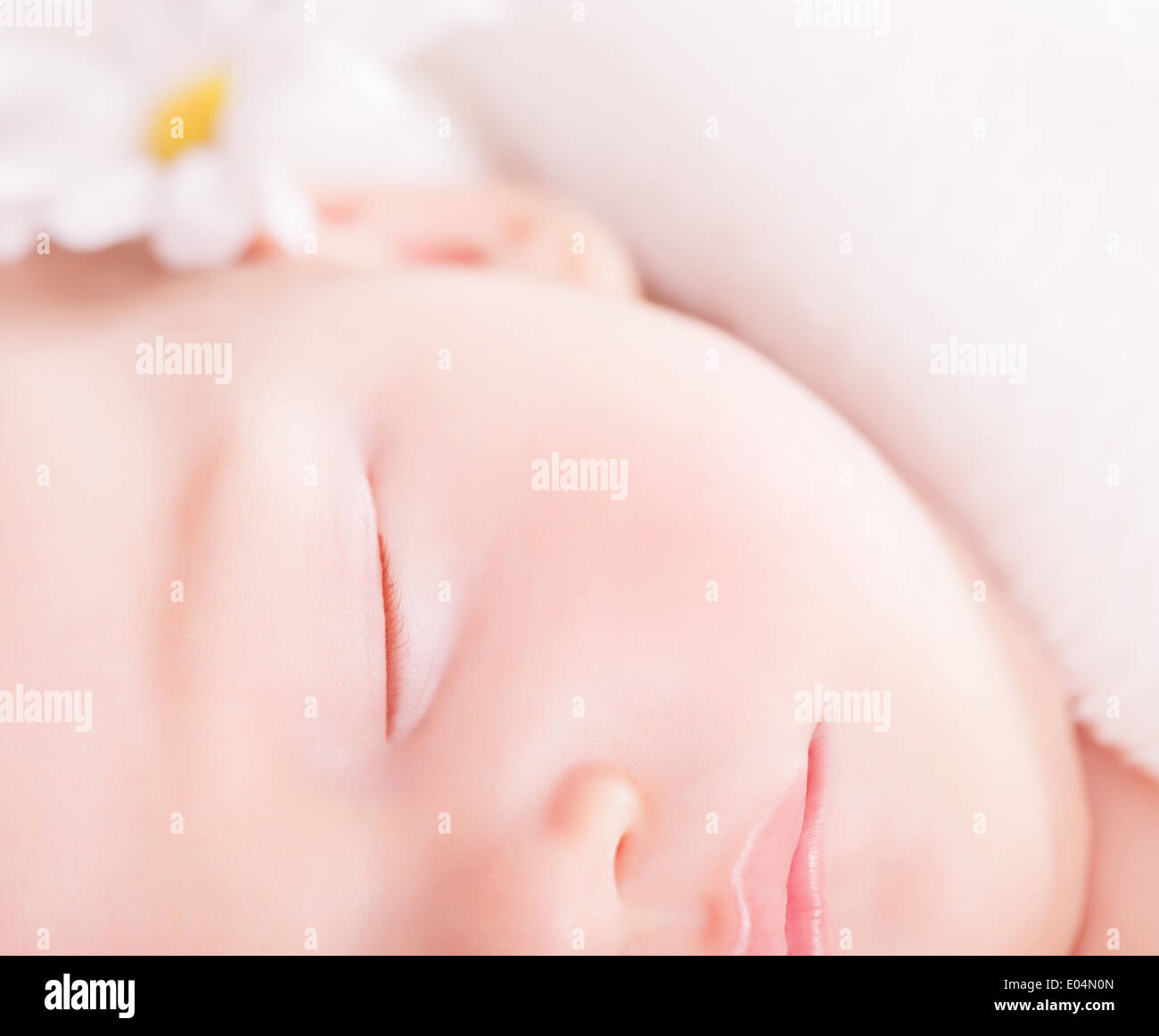 Closeup portrait of cute little baby sleep, face part, gentle daisy flower decoration, carefree childhood, purity and innocence Stock Photo
