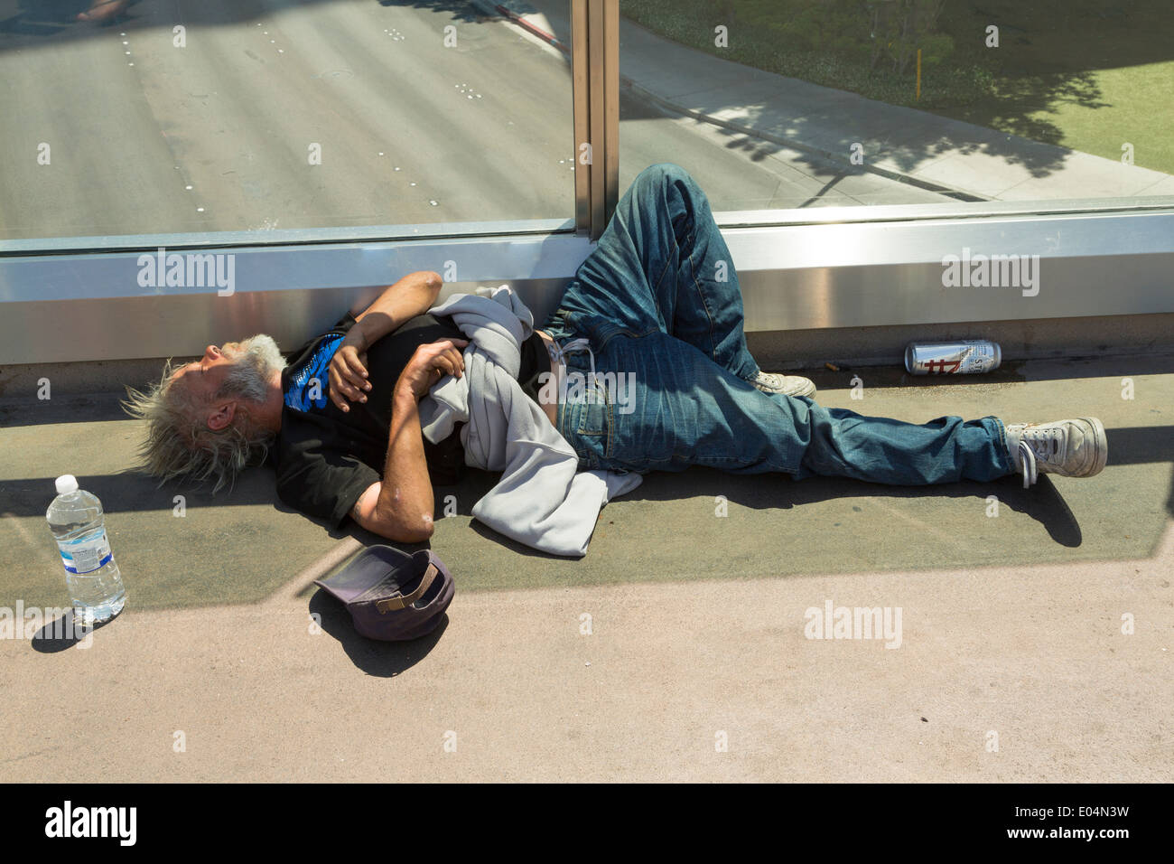Drunk and homeless old man laying asleep on the floor of a pedestrian walkway in Las Vegas, Nevada USA Stock Photo