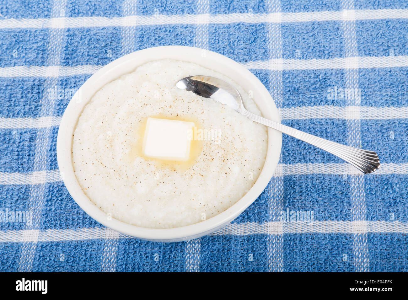A bowl of fresh, hot grits with a spoon Stock Photo