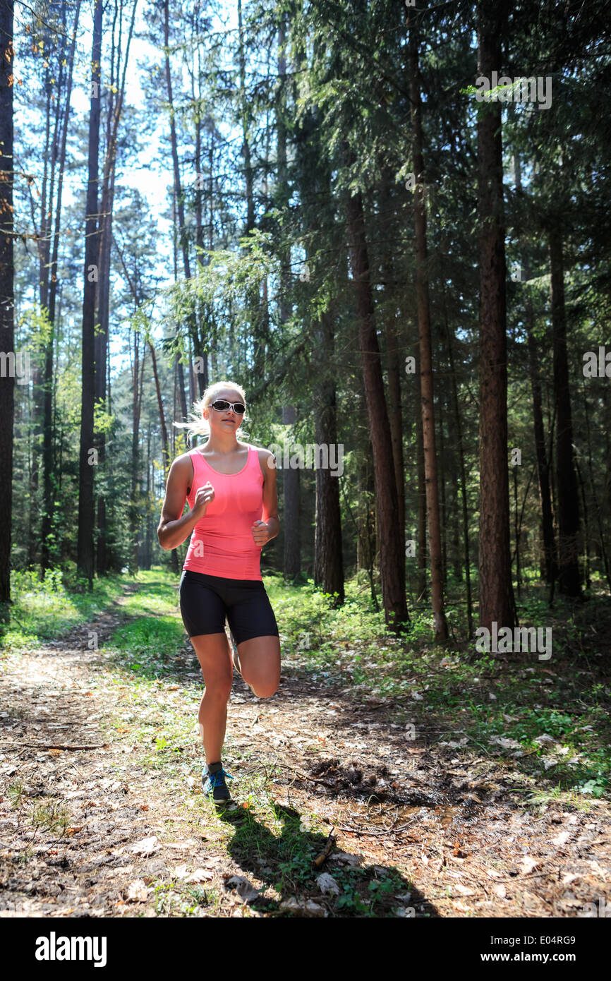 a young woman jogging through the forest Stock Photo - Alamy