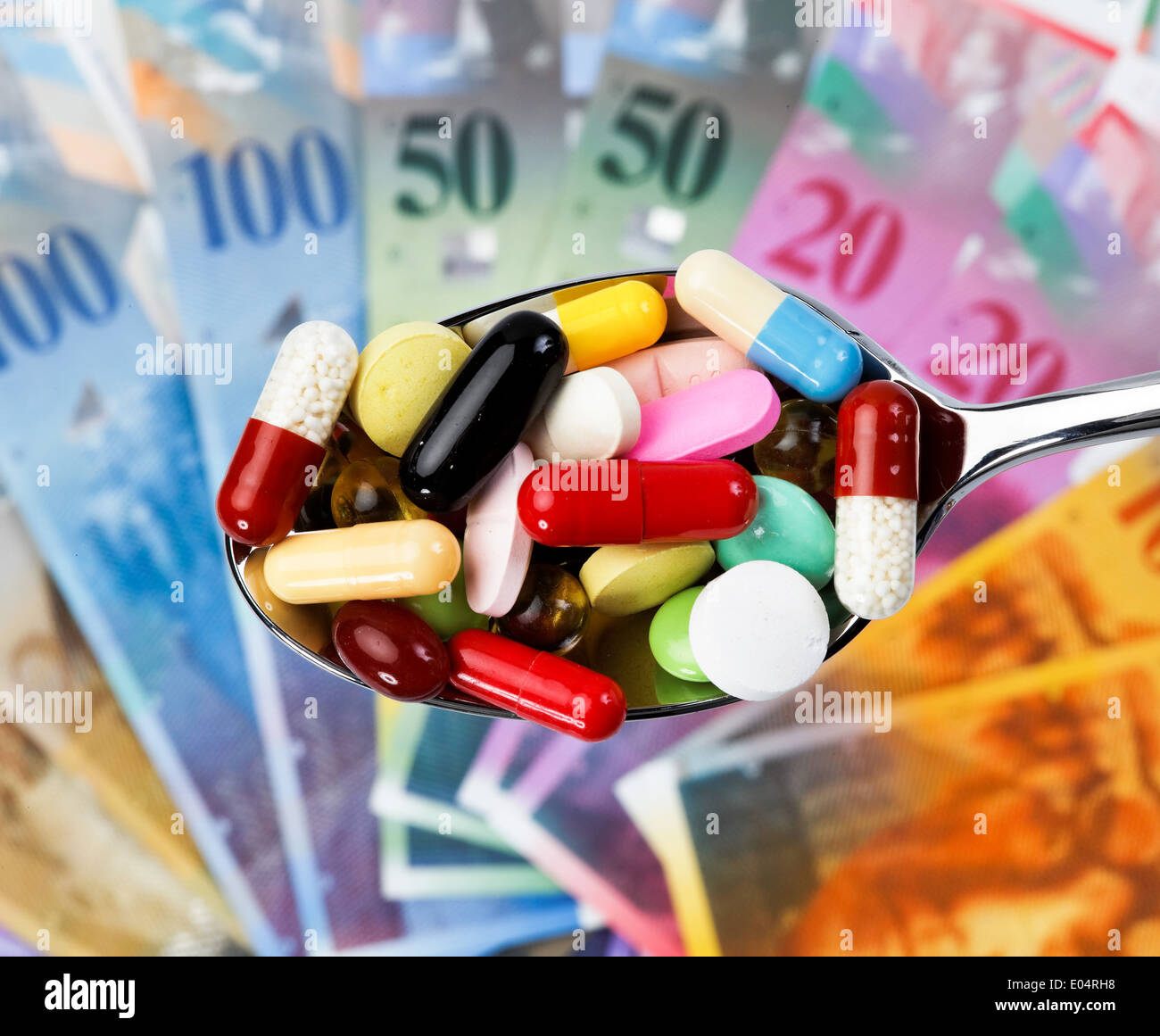 Swiss francs and tablets ace a symbol for health costs, Schweizer Franken und Tabletten als Symbol fuer Gesundheitskosten Stock Photo