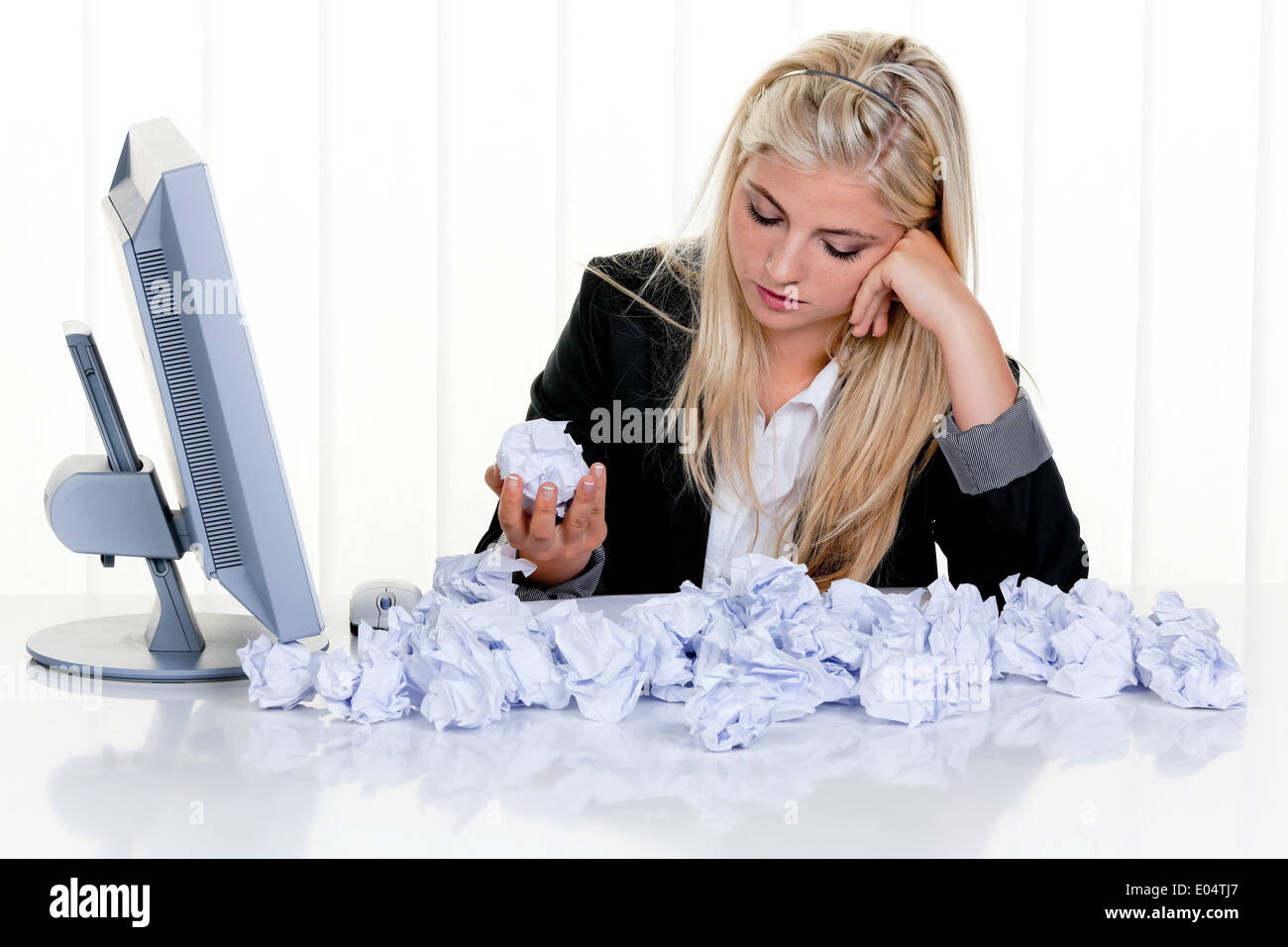 Young woman with of paper looks for idea, Junge Frau mit Papier sucht nach Idee Stock Photo