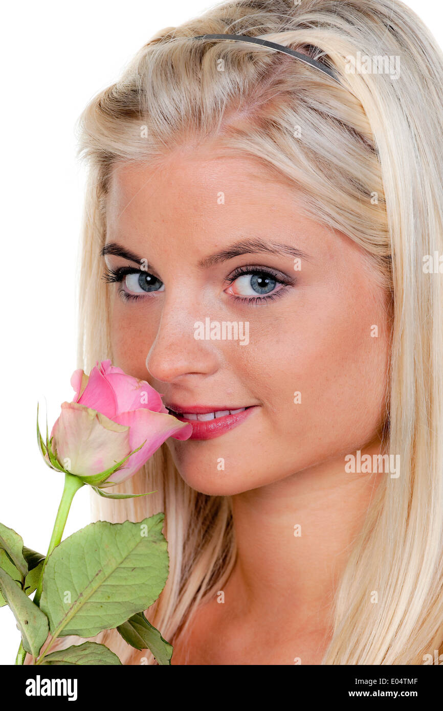 Young woman with a rose in them smells., Junge Frau mit einer Rose an der sie riecht. Stock Photo