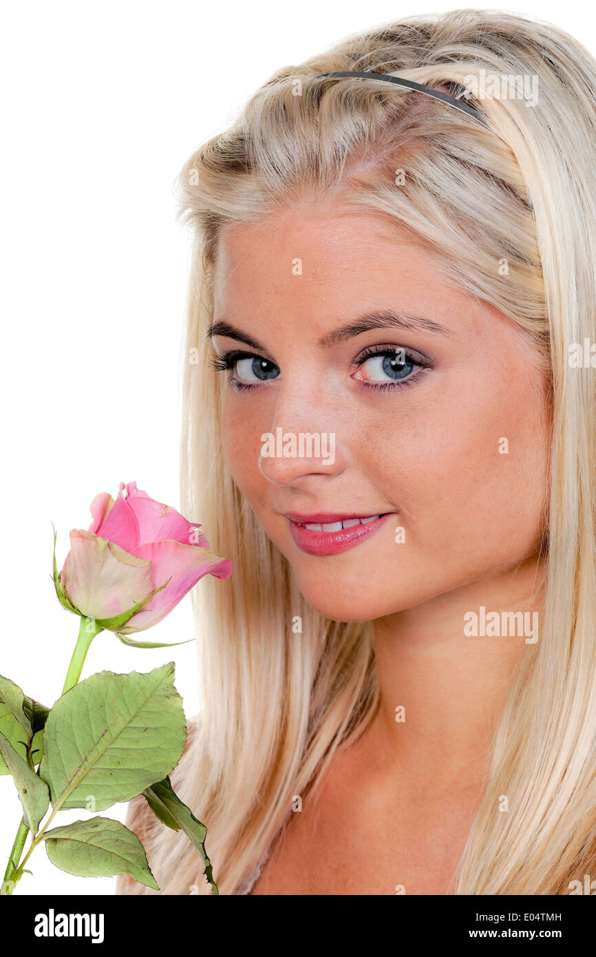 Young woman with a rose in them smells., Junge Frau mit einer Rose an der sie riecht. Stock Photo