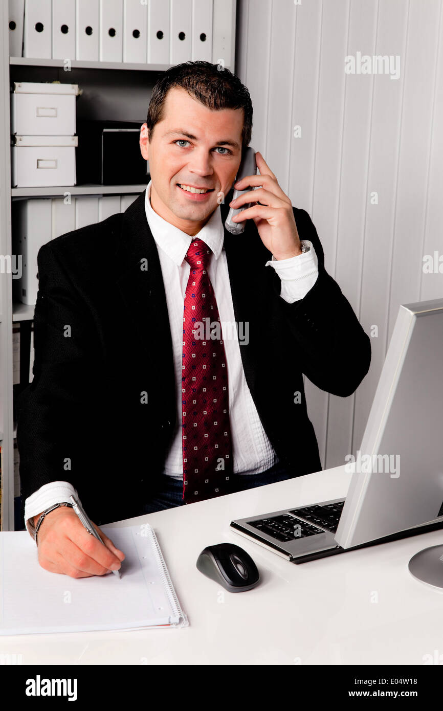 Young businessman in the office with phone, Junger Geschaeftsmann im Buero mit Telefon Stock Photo