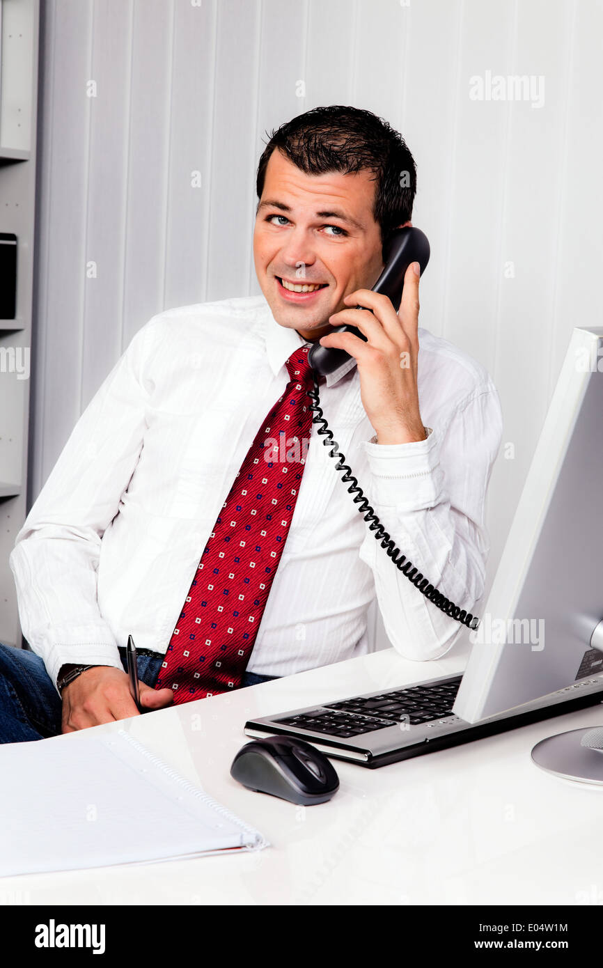 Young businessman in the office with phone, Junger Geschaeftsmann im Buero mit Telefon Stock Photo