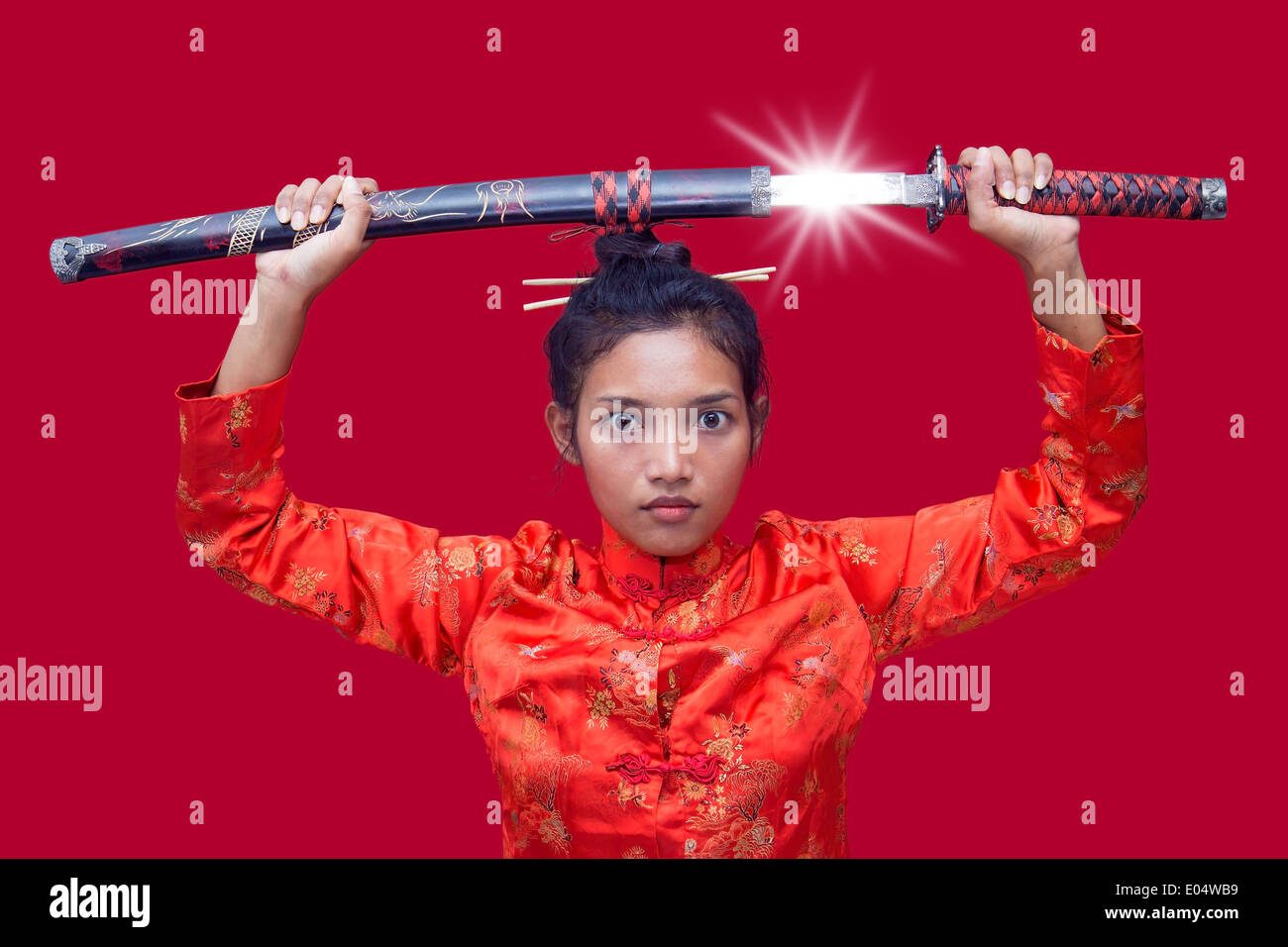 Asian woman holding a samurai sword over his head Stock Photo