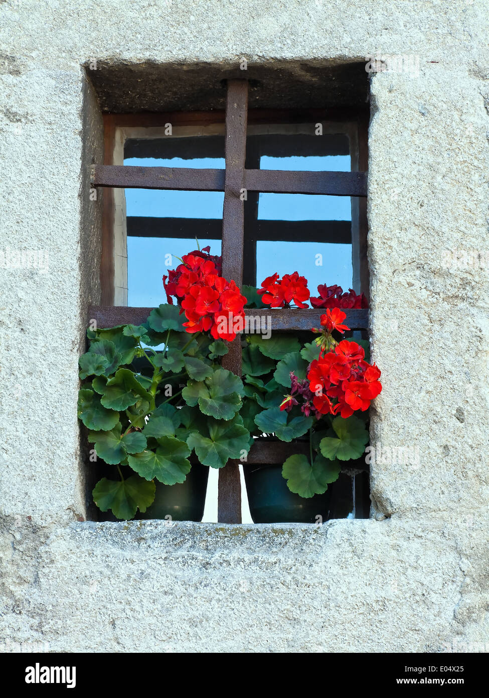 Small old window of a house with flowers, Kleines altes Fenster eines Hauses mit Blumen Stock Photo