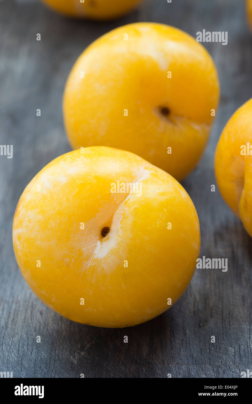 Yellow plums on dark wooden table, closeup, selective focus Stock Photo