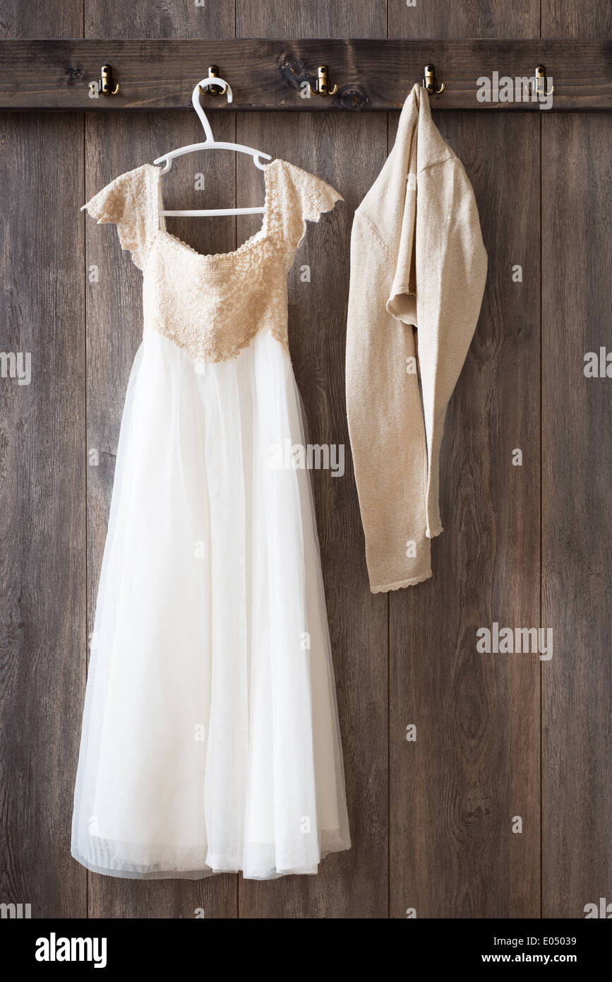 Bridesmaid dress and cardigan hanging from hooks Stock Photo Alamy