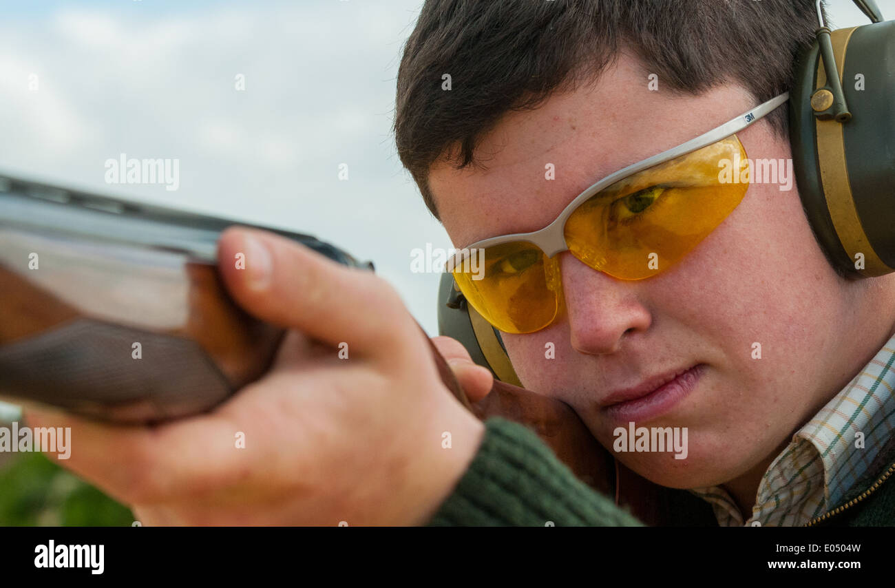 Young man with an over and under shot gun at a clay pigeon shooting ...