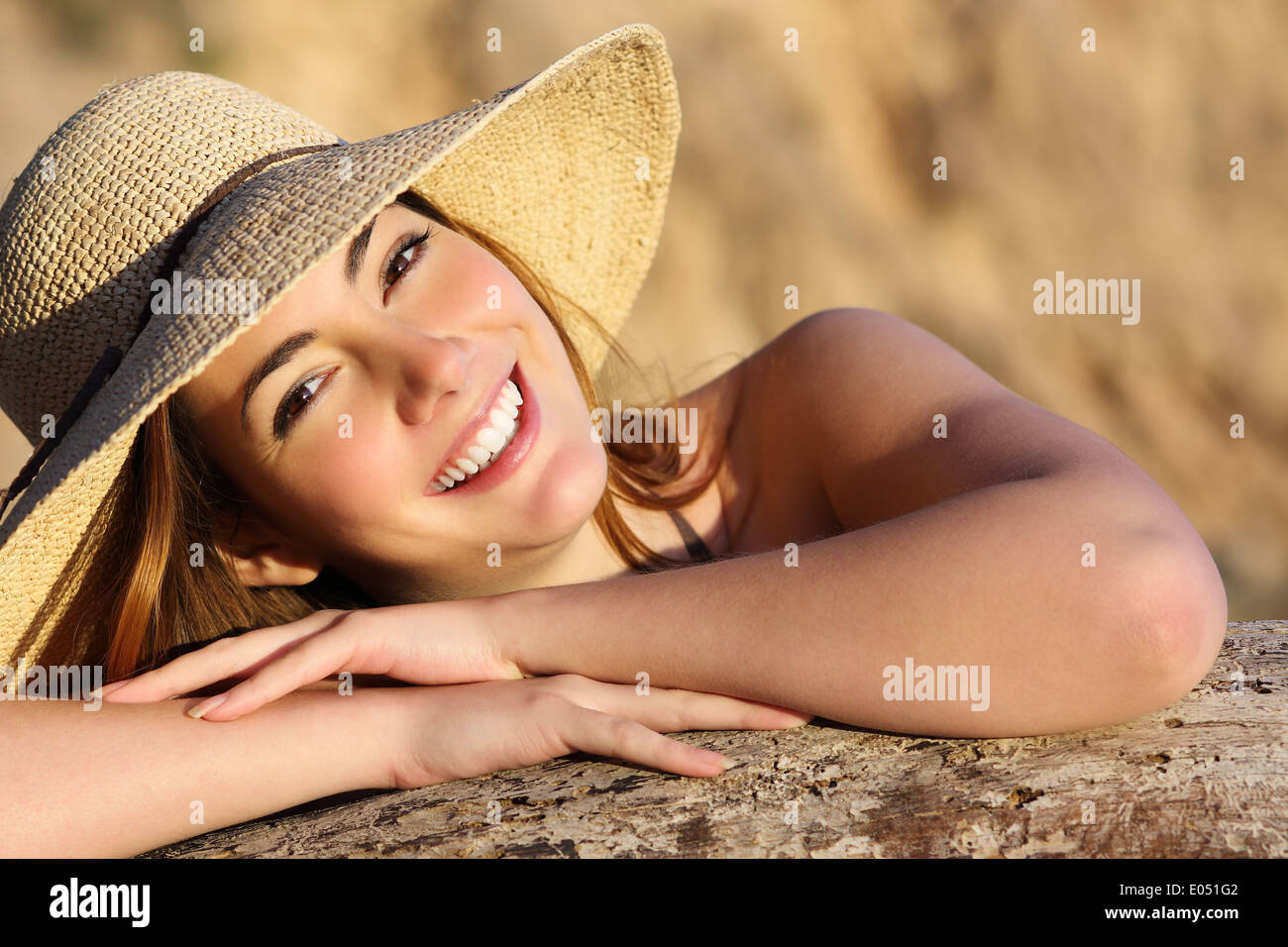Portrait of a happy woman smiling with perfect white smile with a warm light and background Stock Photo