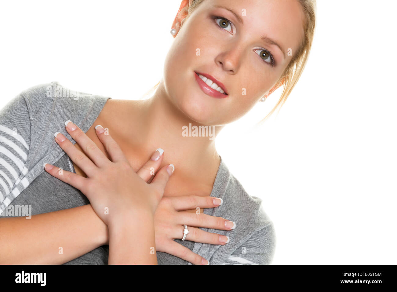 A young woman holds her hands before her body. Symbolic photo for protective need, insecurity and thoughtfulness, Eine junge Fra Stock Photo