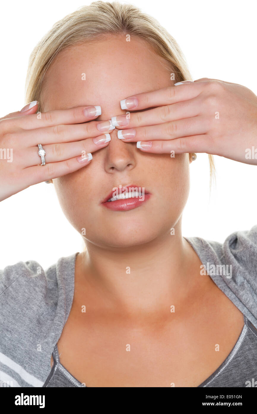 A young woman keeps closed to herself the eyes. Symbolic photo for do not want to see and displacement as well as quarrel avoida Stock Photo