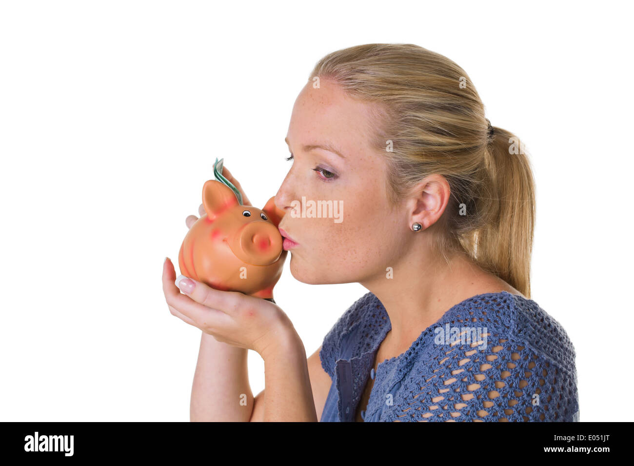 A young woman before white background with a piggy bank. Money save as old-age provisions., Eine junge Frau vor weissem Hintergr Stock Photo