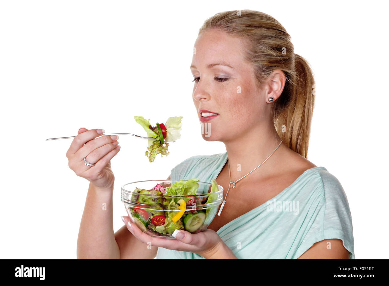 A young woman eats a crisp salad in the lunchbreak. Healthy food with vitamins., Eine junge Frau isst einen knackigen Salat in d Stock Photo