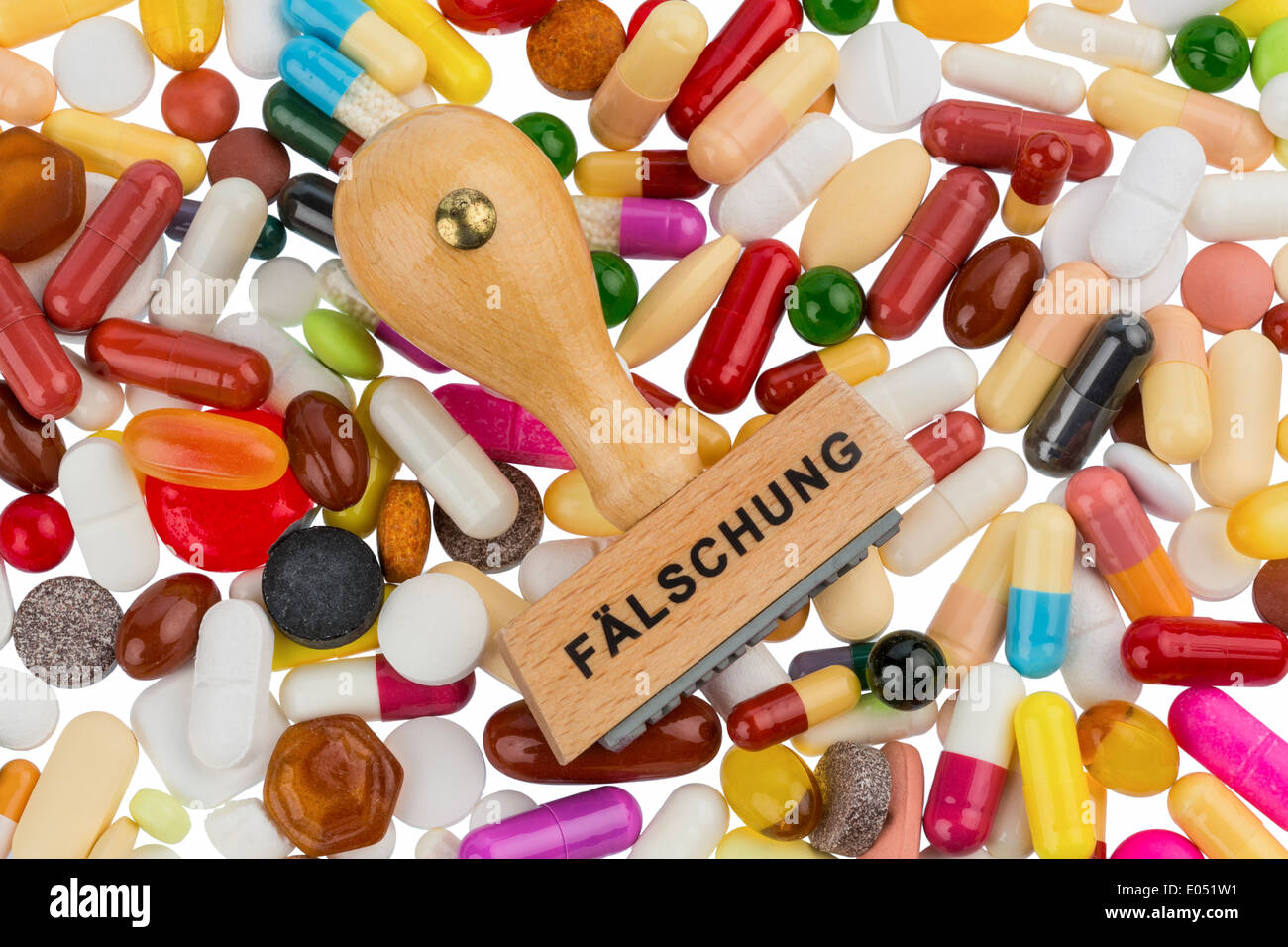 Stamp on coloured tablets, symbolic photo for drug forgery and product piracy, Stempel auf bunten Tabletten, Symbolfoto fuer Med Stock Photo