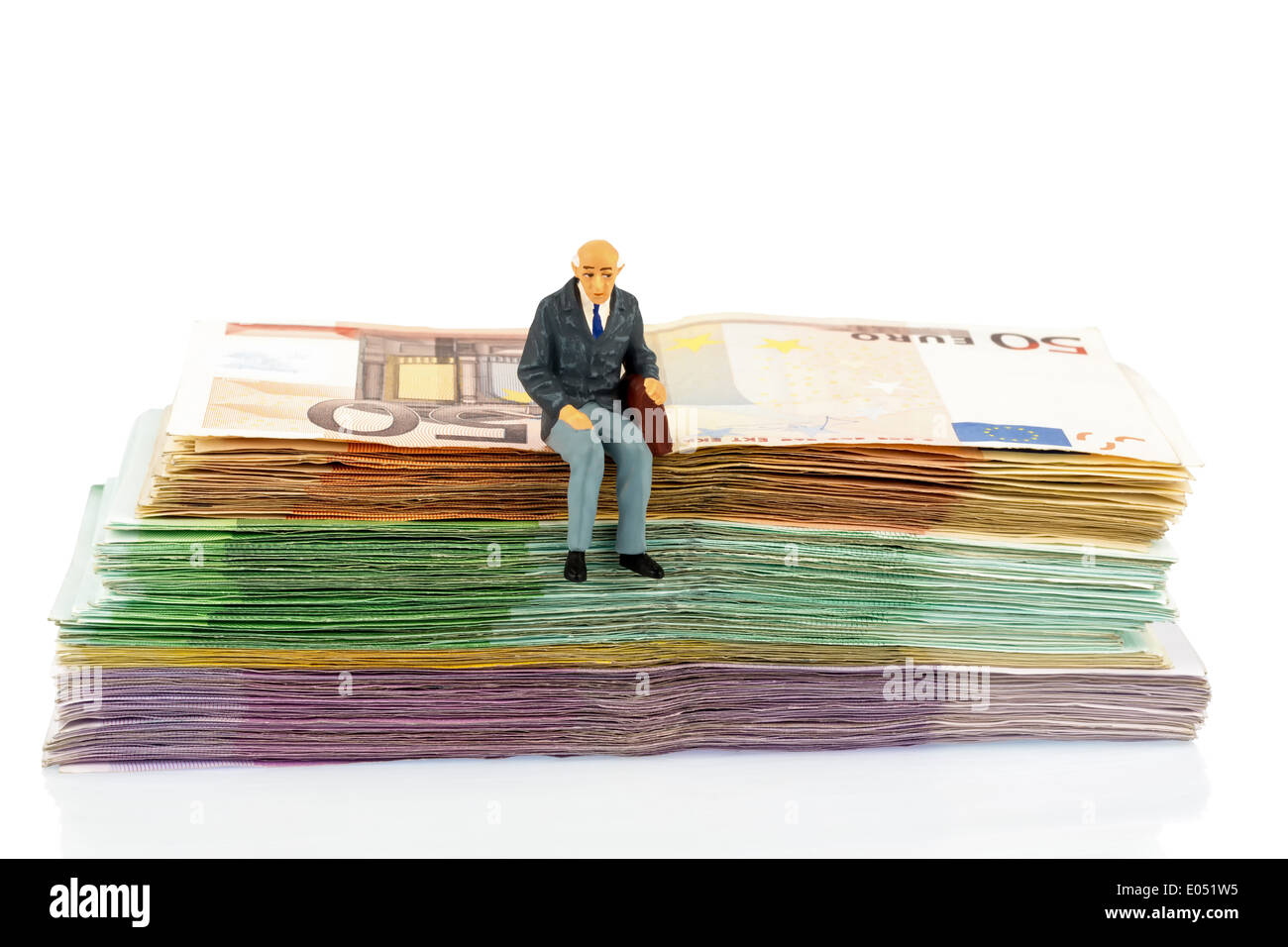 Symbolic photo for retirement and provision for the old age, figure of an old man sits on a pile of bank notes, Symbolfoto fuer Stock Photo