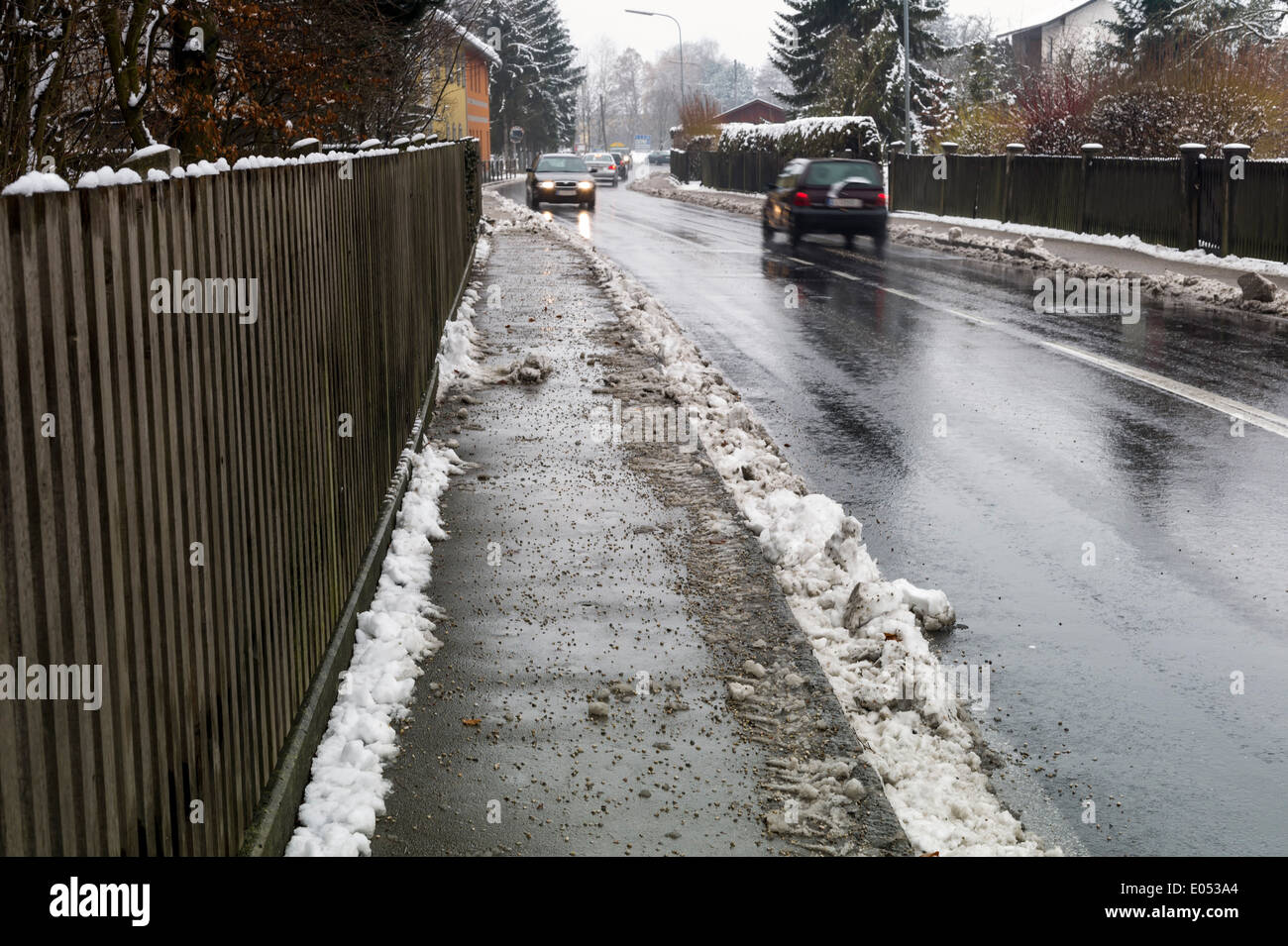 Snow on sidewalk and street, symbolic photo for accident risk and Raeumpflicht, Schnee auf Gehweg und Strasse, Symbolfoto fuer U Stock Photo