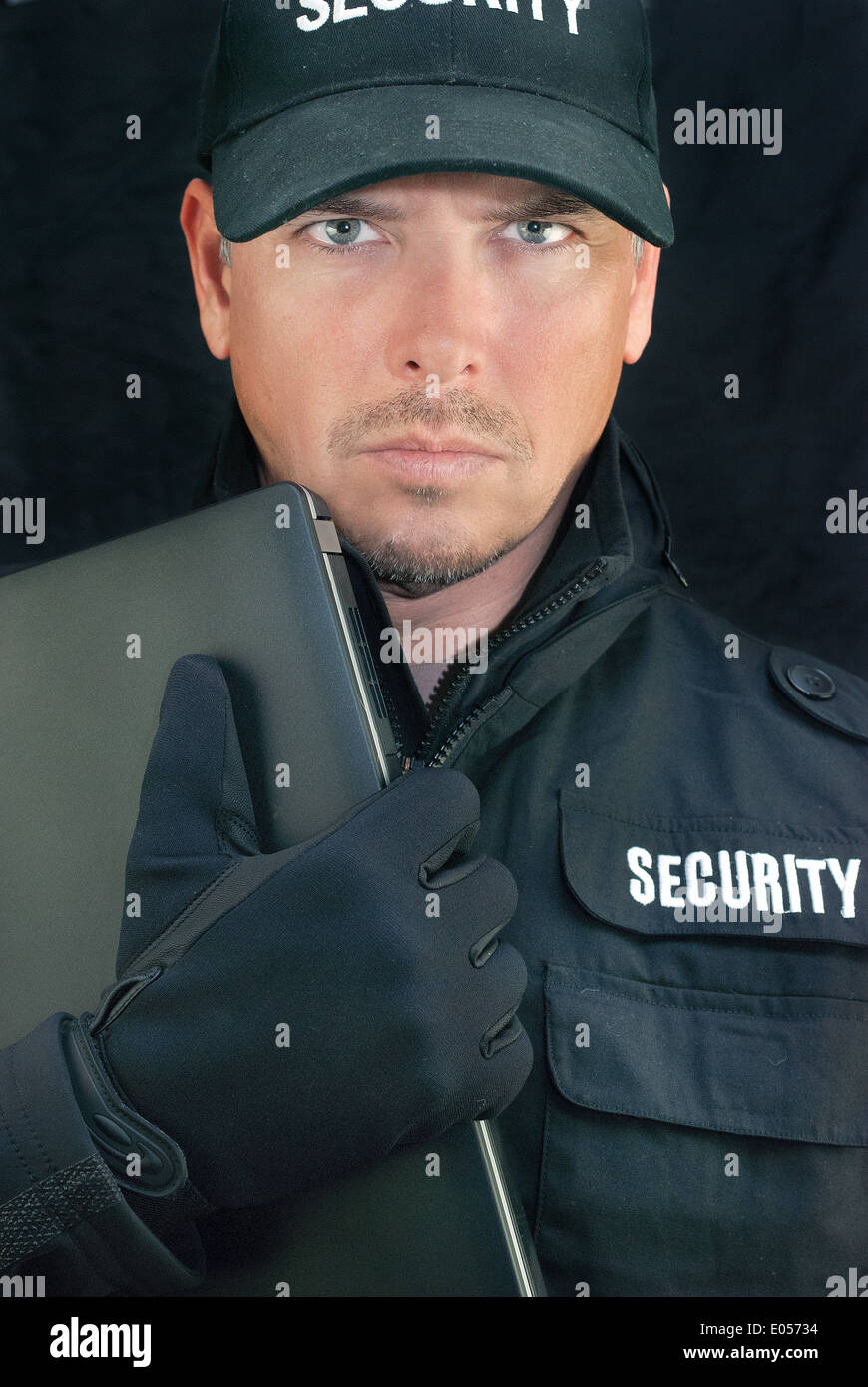 Close-up of security holding a laptop to camera. Stock Photo