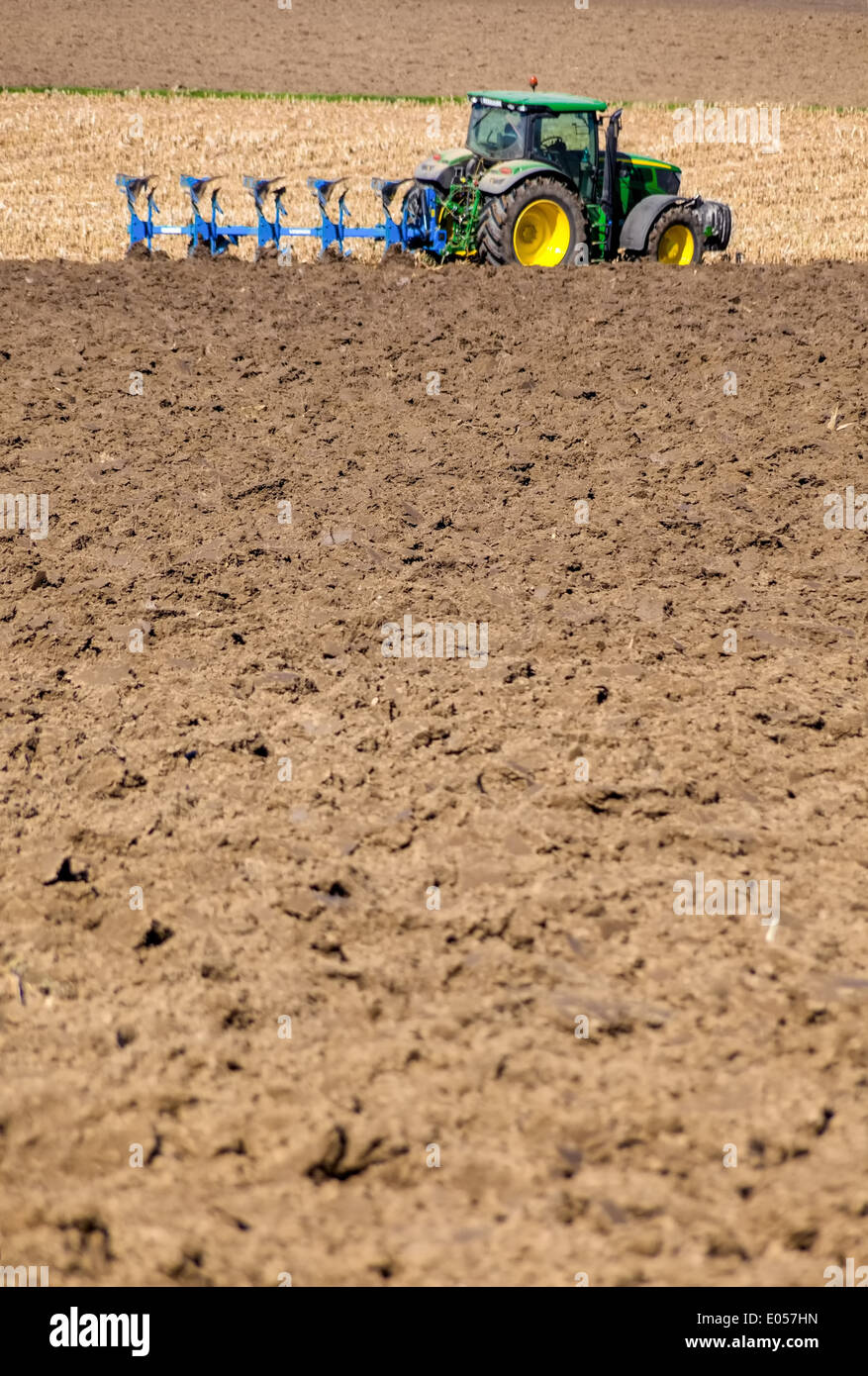 A tractor on a field plough with. Text clearance in the foreground, Ein Traktor auf einem Feld beim pfluegen. Textfreiraum im Vo Stock Photo