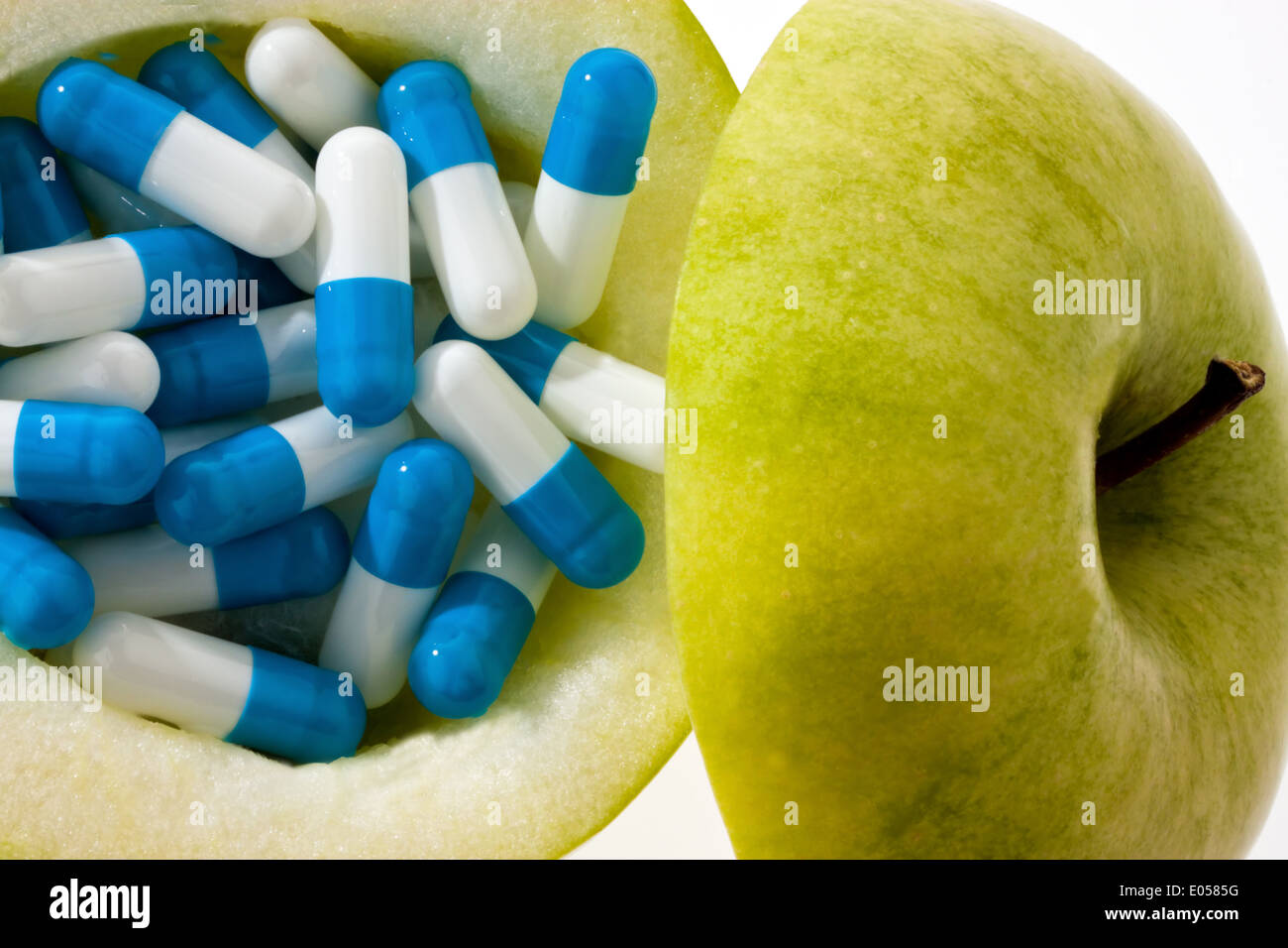Apple with tablets capsules. Symbolic photo for vitamin tablets, Apfel mit Tabletten Kapseln. Symbolfoto fuer Vitamintabletten Stock Photo