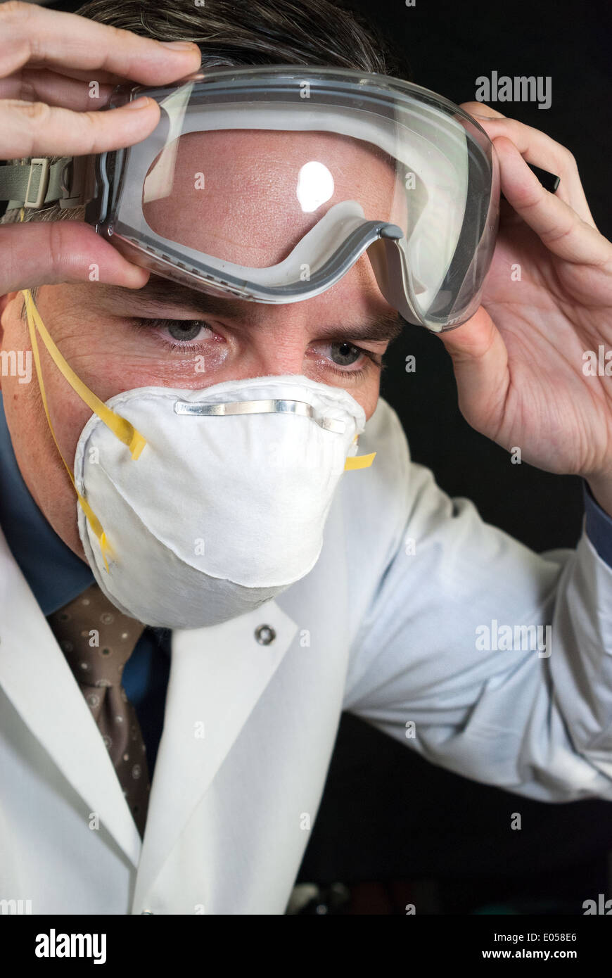 Close-up of a Doctor wearing a mask and putting on goggles. Stock Photo