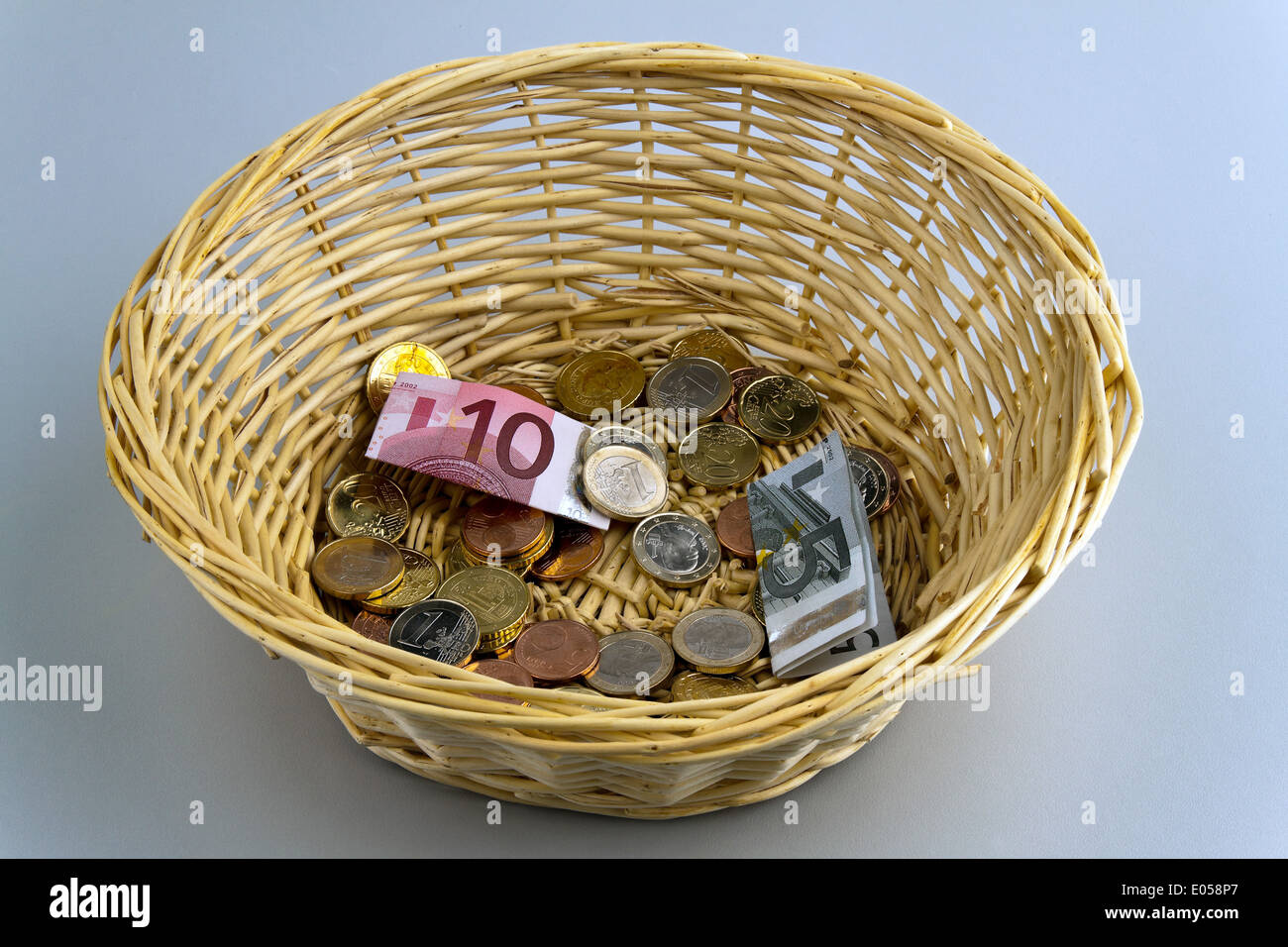 A donation basket for collection. Money donation with euro, Ein Spendenkorb fuer Sammlung. Geld Spende mit Euro Stock Photo