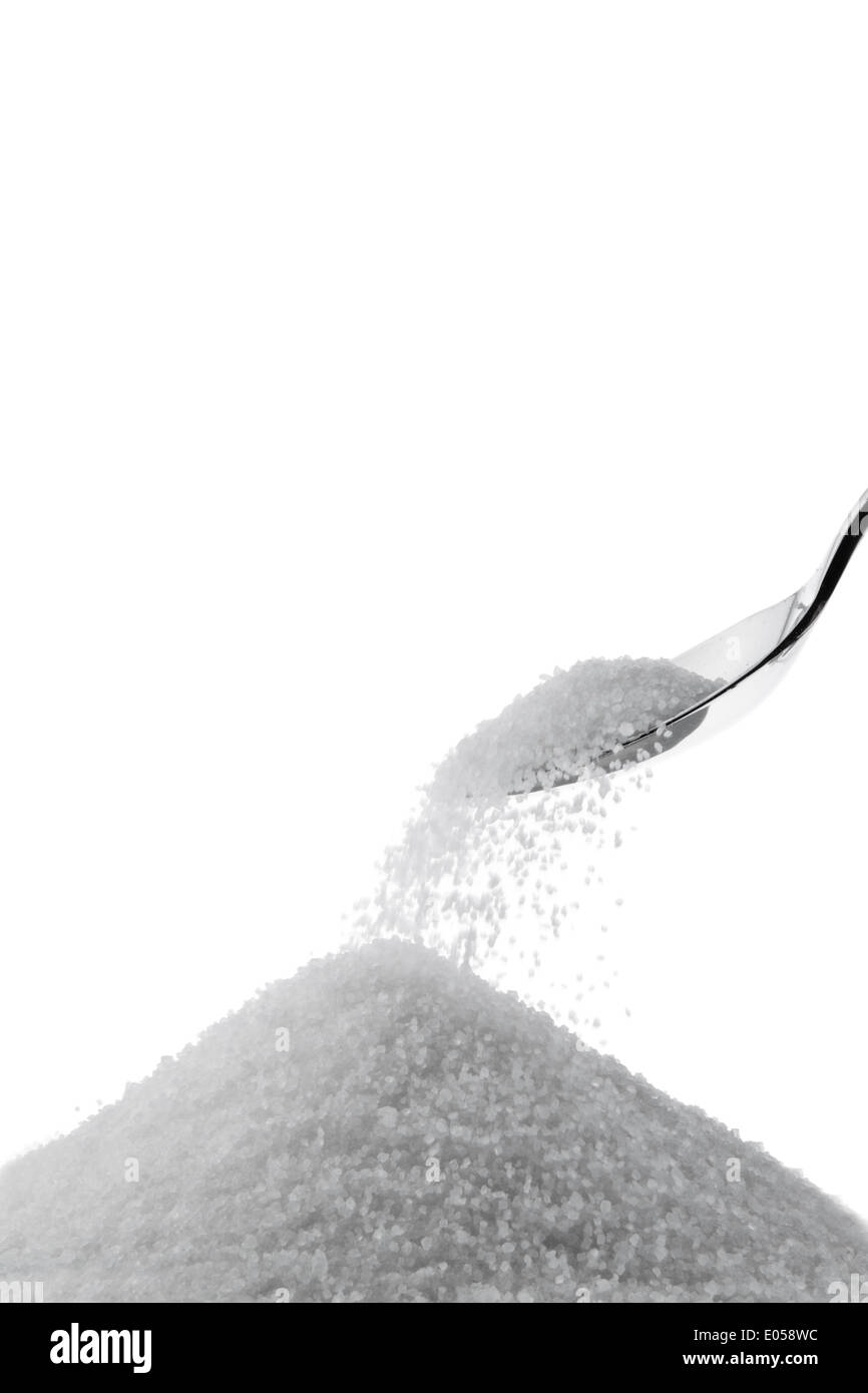 Fine crystal sugar on a spoon. Isolated before white background, Feiner Kristall Zucker auf einem Loeffel. Isoliert vor weissem Stock Photo