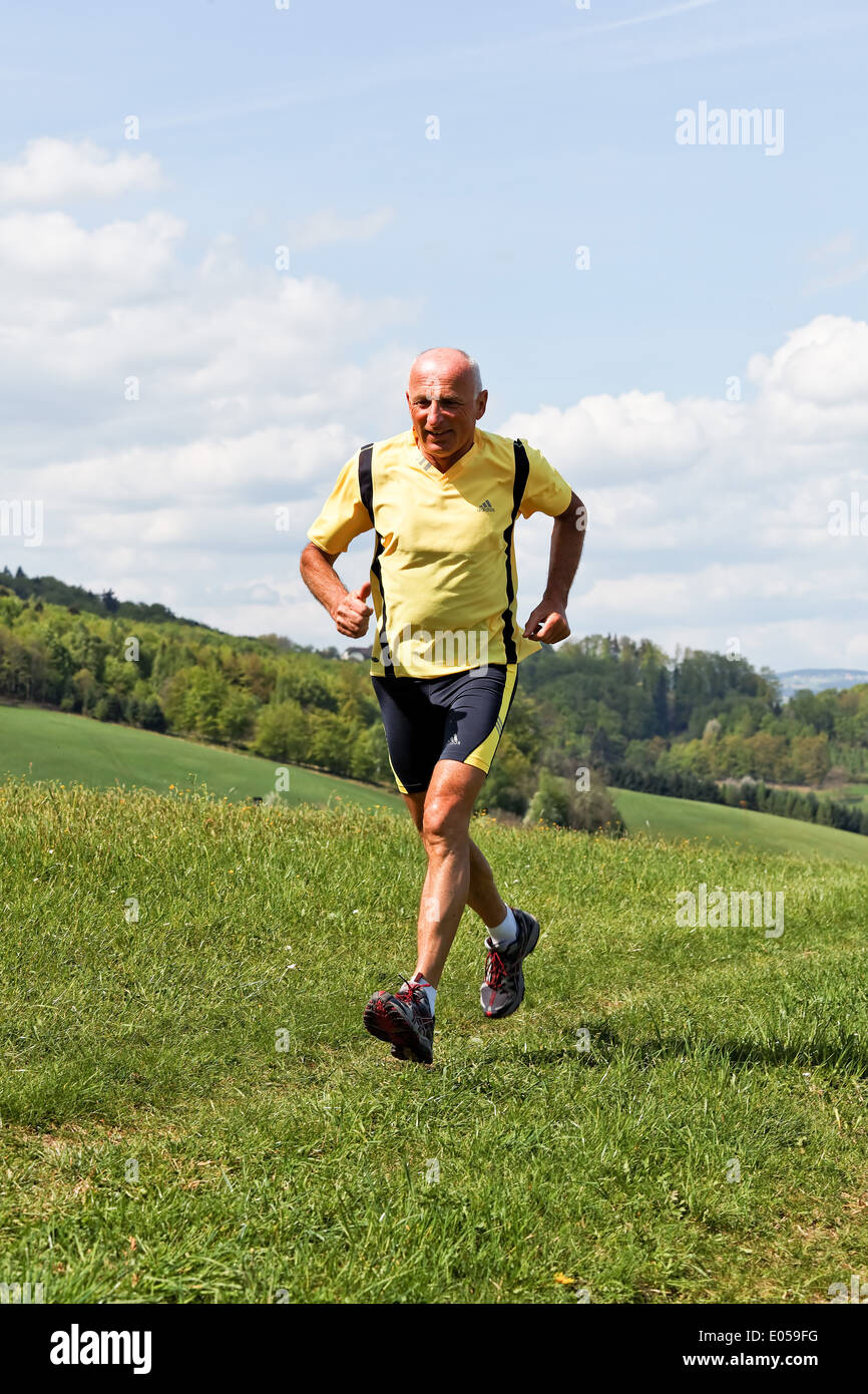 Senior citizens jogger trains for his fitness with running, Senioren Jogger trainiert fuer seine Fitness mit Laufen Stock Photo
