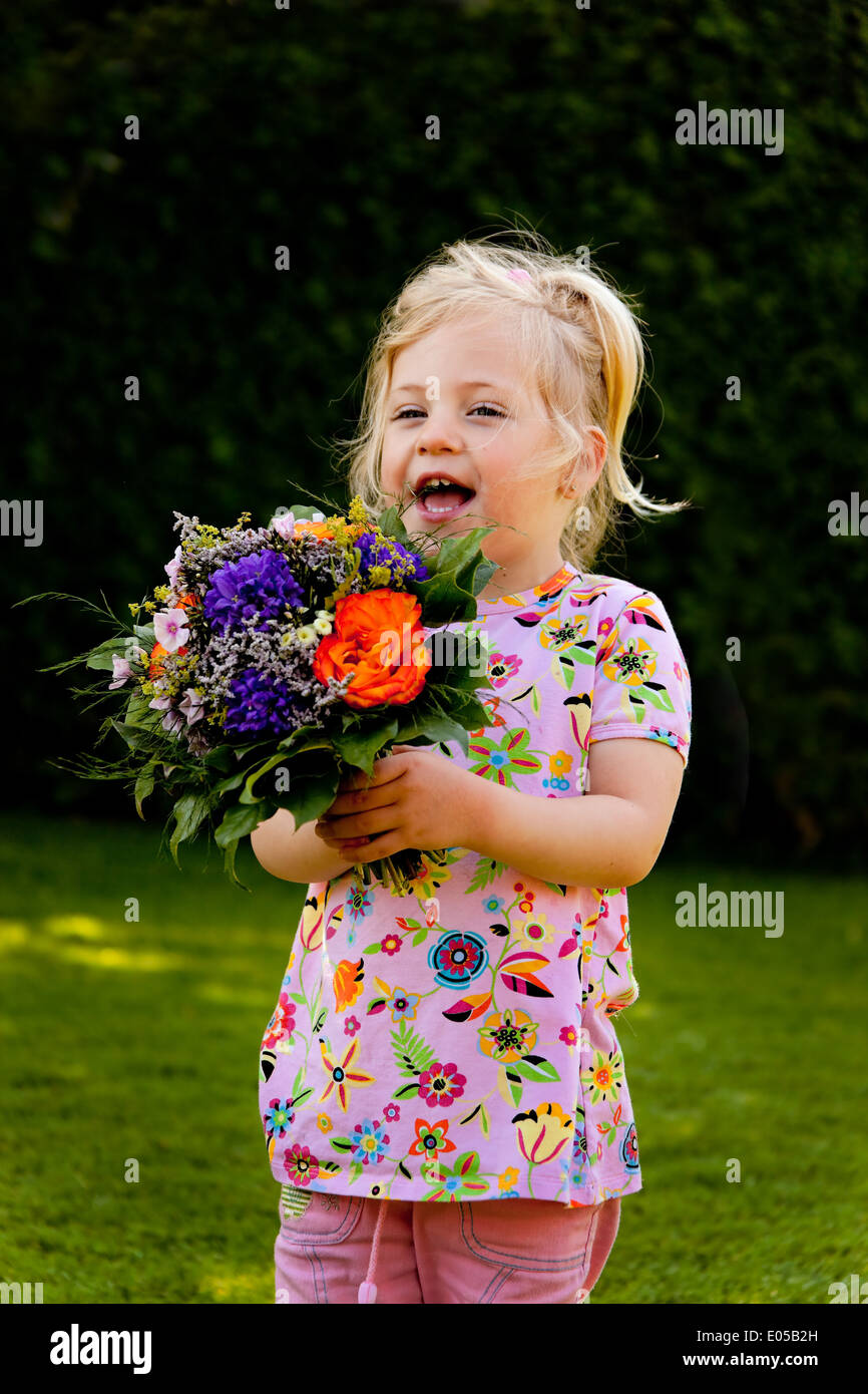 Small child with bouquet. Present for Mother's Day, Kleines Kind mit Blumenstrauss. Geschenk fuer Muttertag Stock Photo